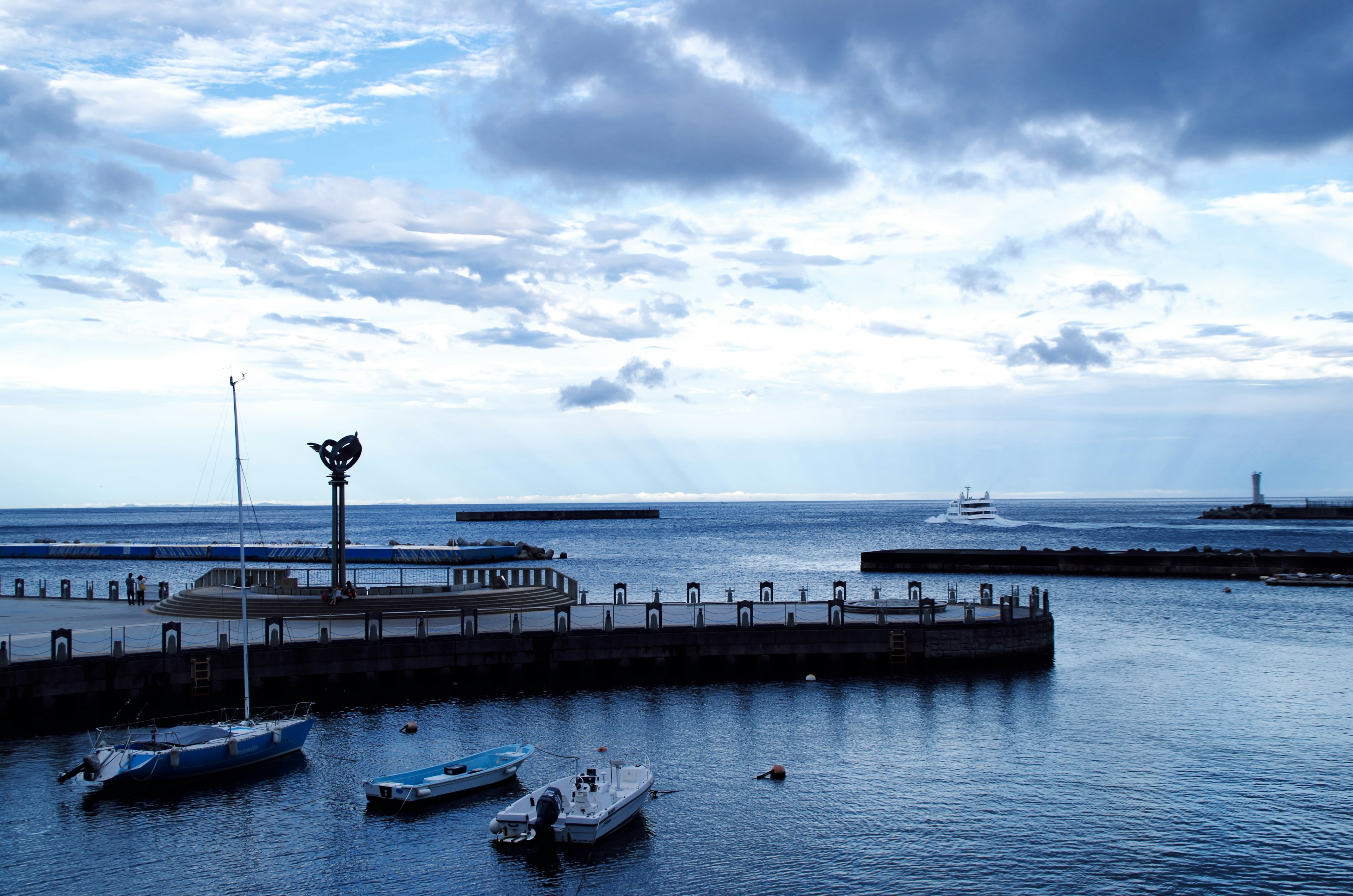 Harbor scene with small boats under a blue sky and sea