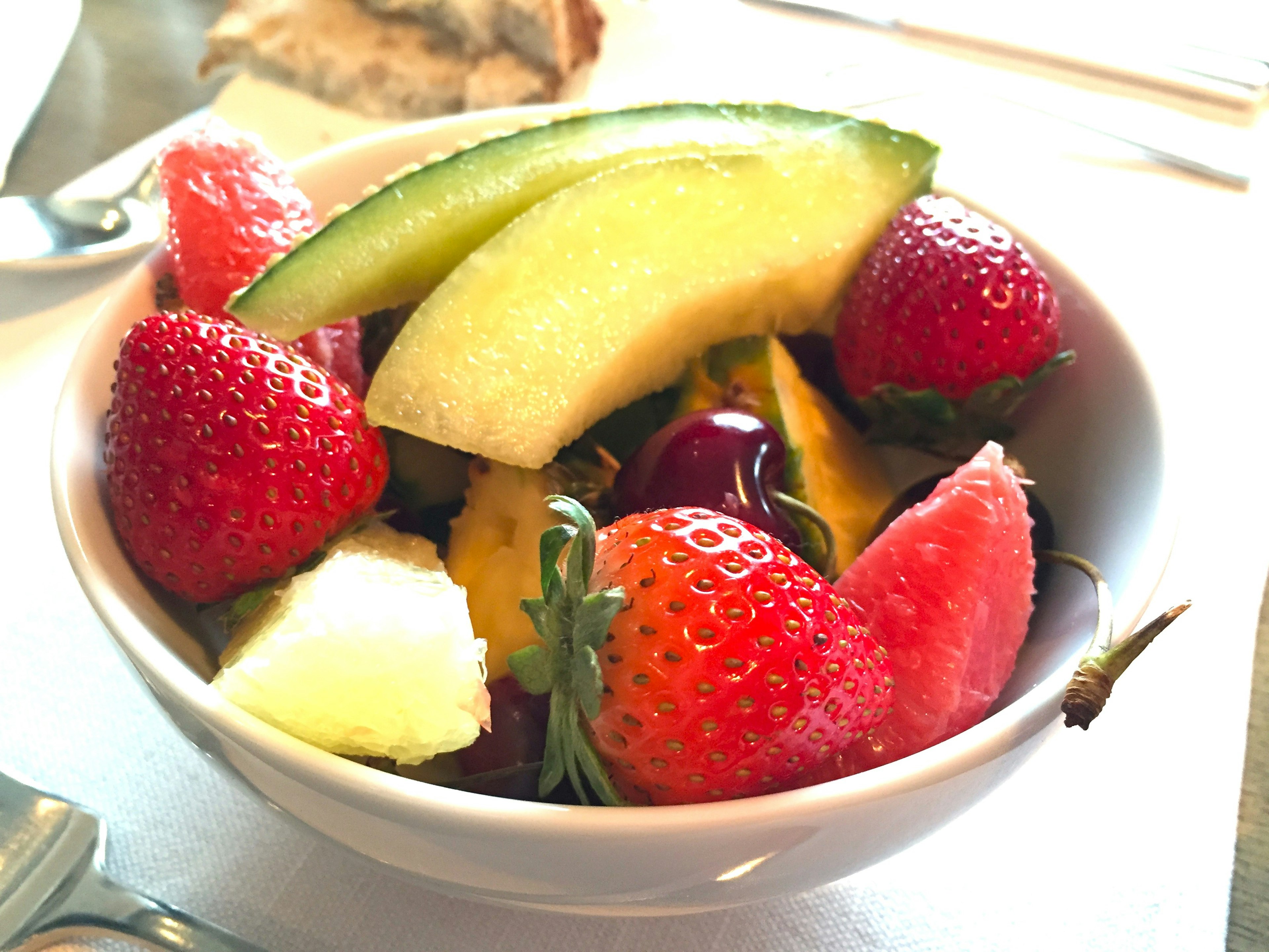 Bowl of fresh fruit including strawberries, melon, mango, and watermelon