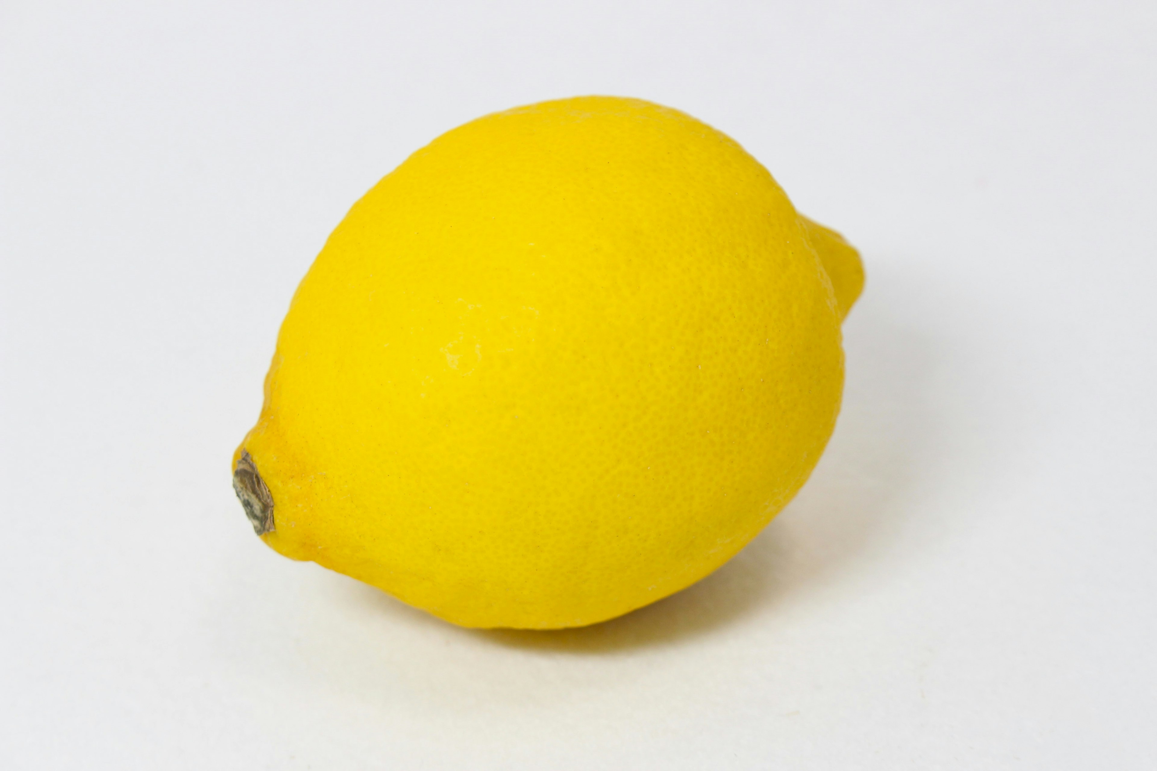 A vibrant yellow lemon placed on a white background