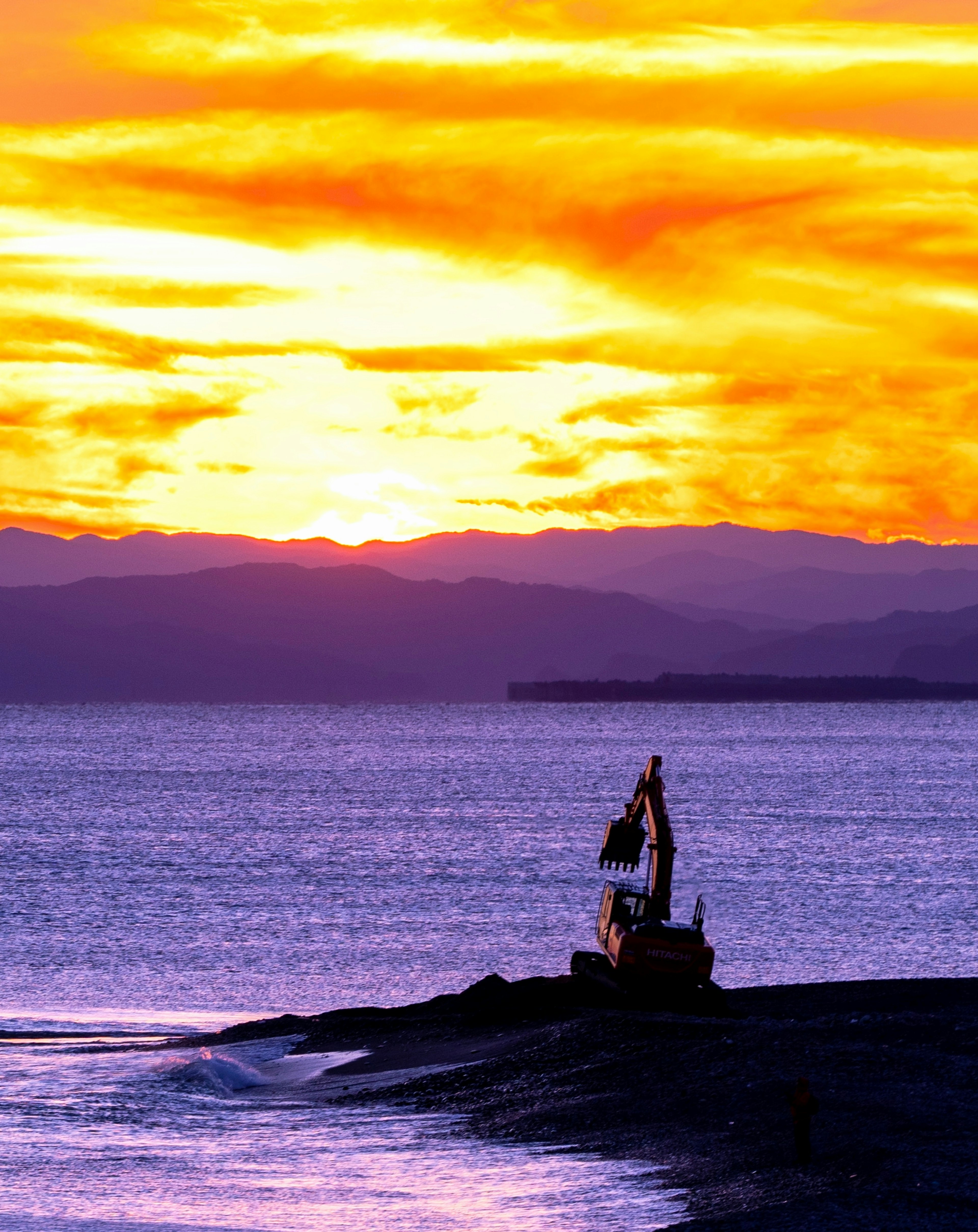 美しい夕焼けの海岸線に立つ小舟のシルエット