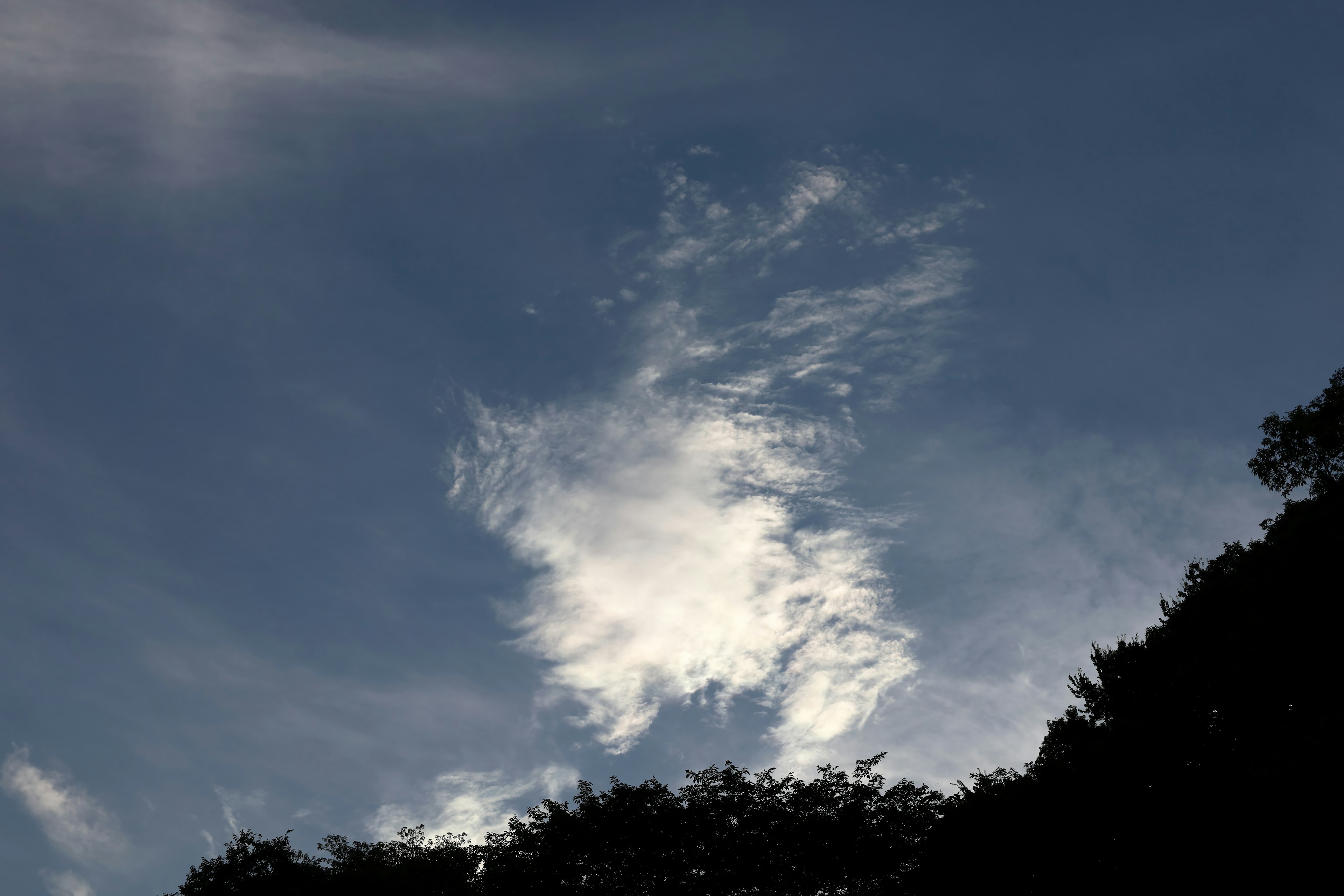 Silhouette of white clouds against a blue sky