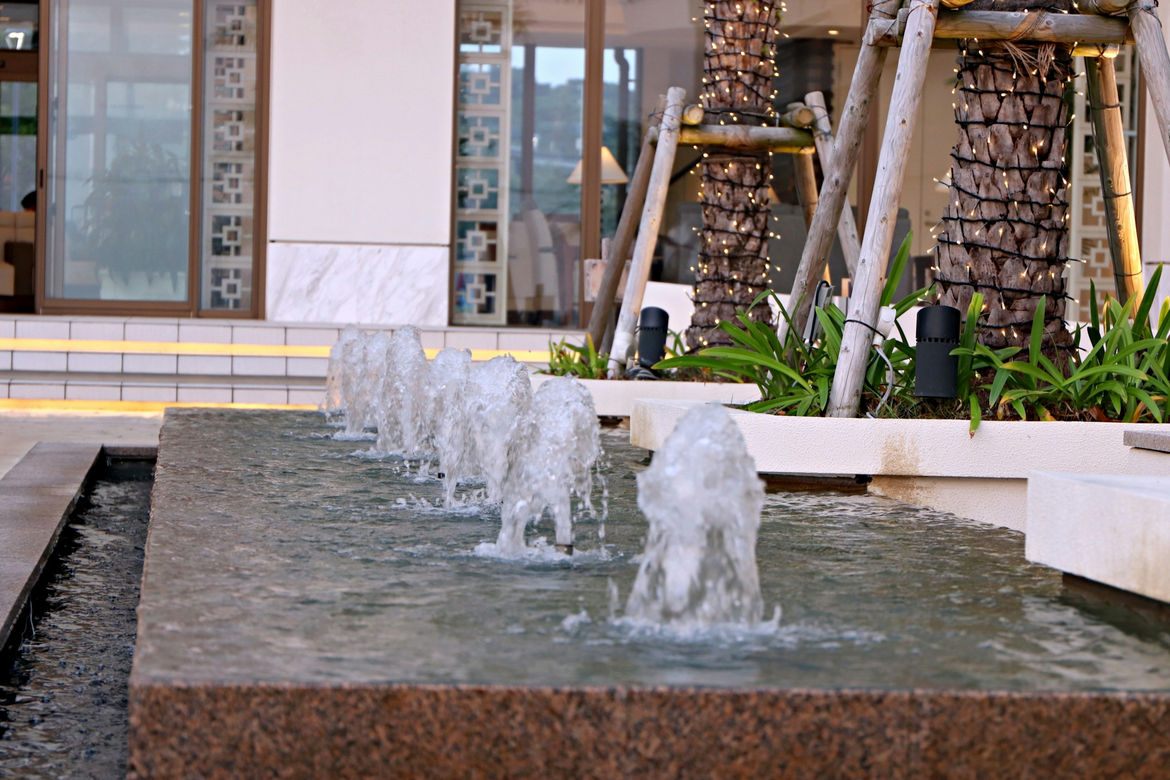 Scène de cour moderne avec une fontaine et de la verdure