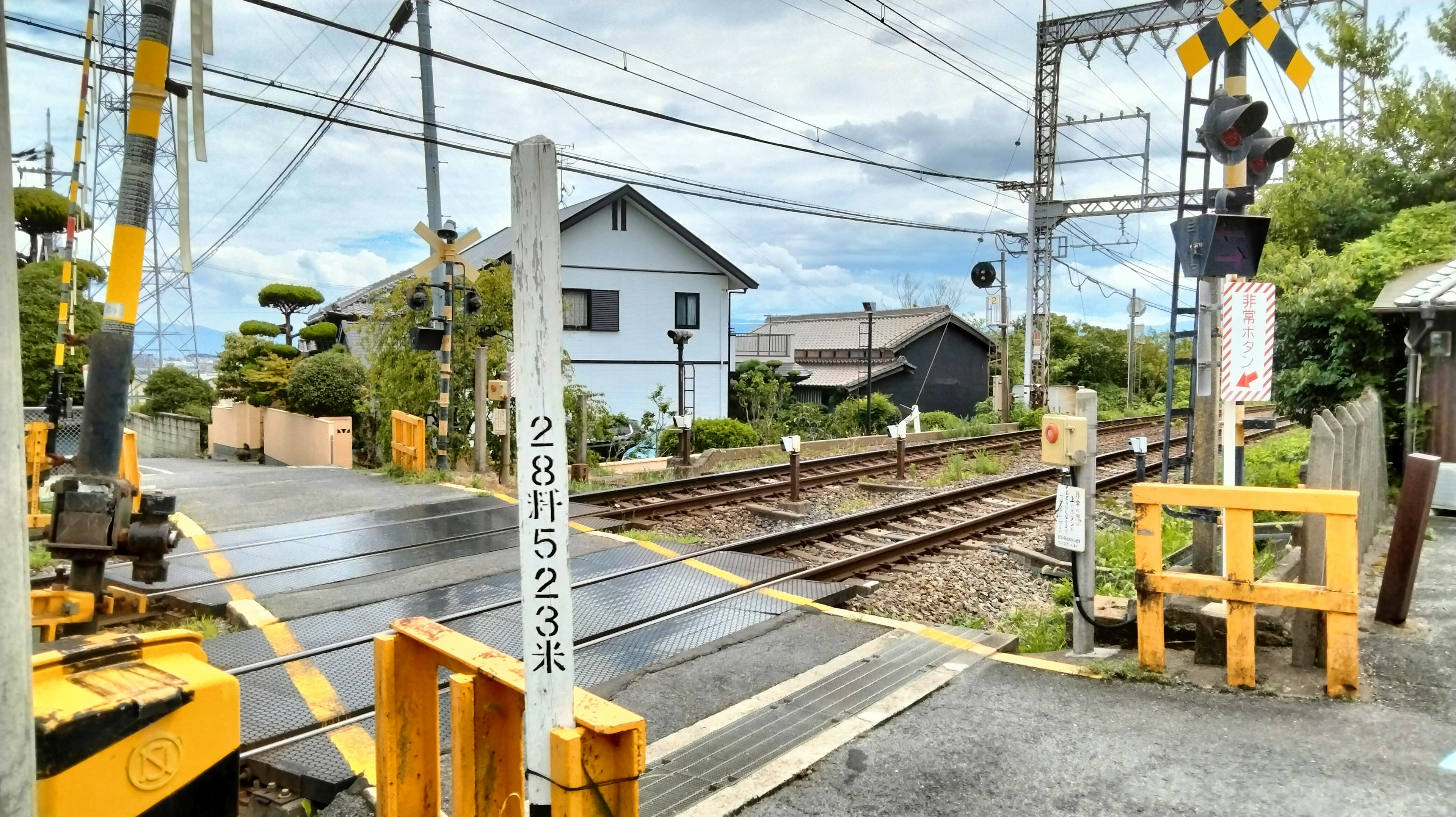 宁静的乡村场景，有铁路道口和附近的房屋