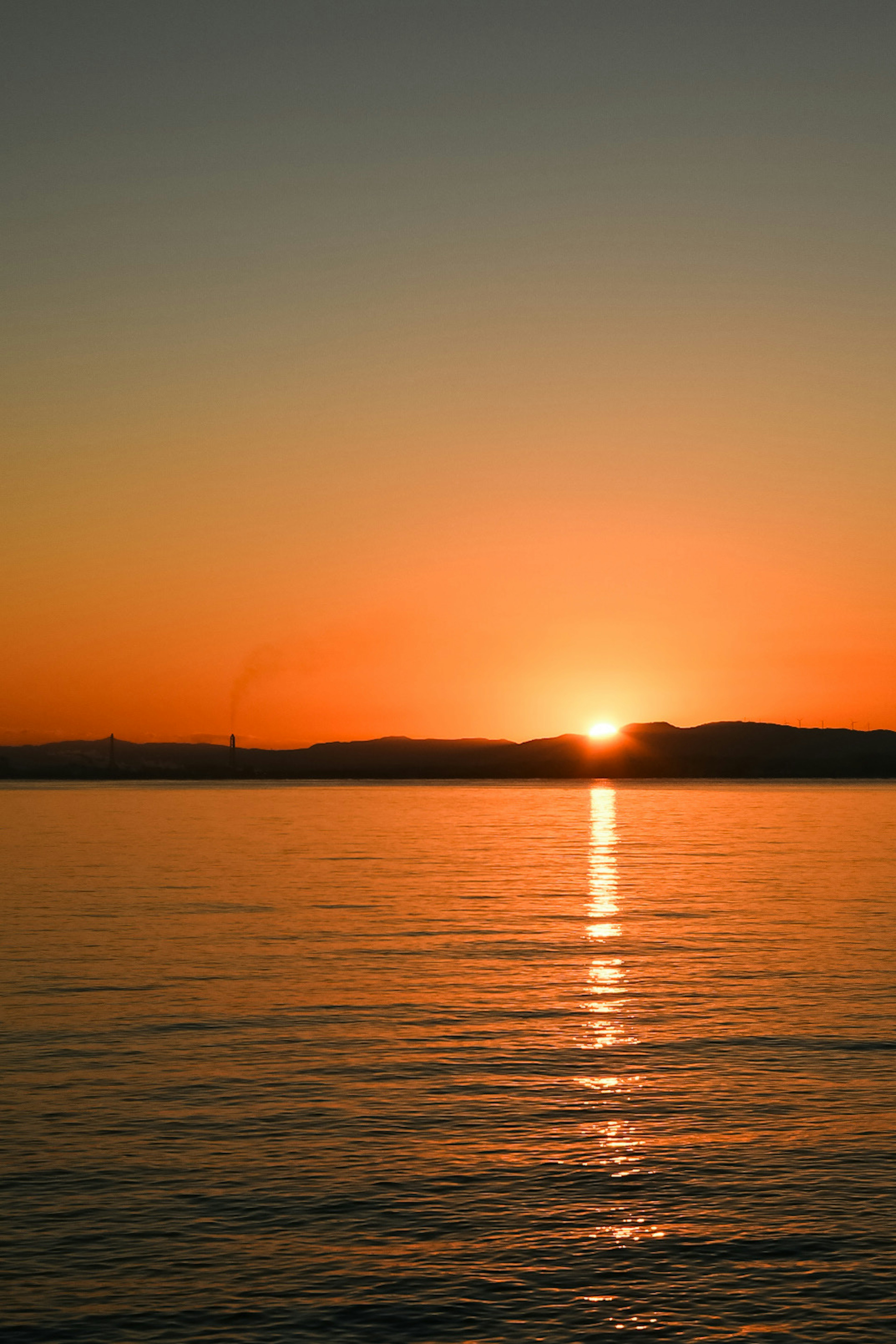 Mer calme avec un coucher de soleil et un ciel orange