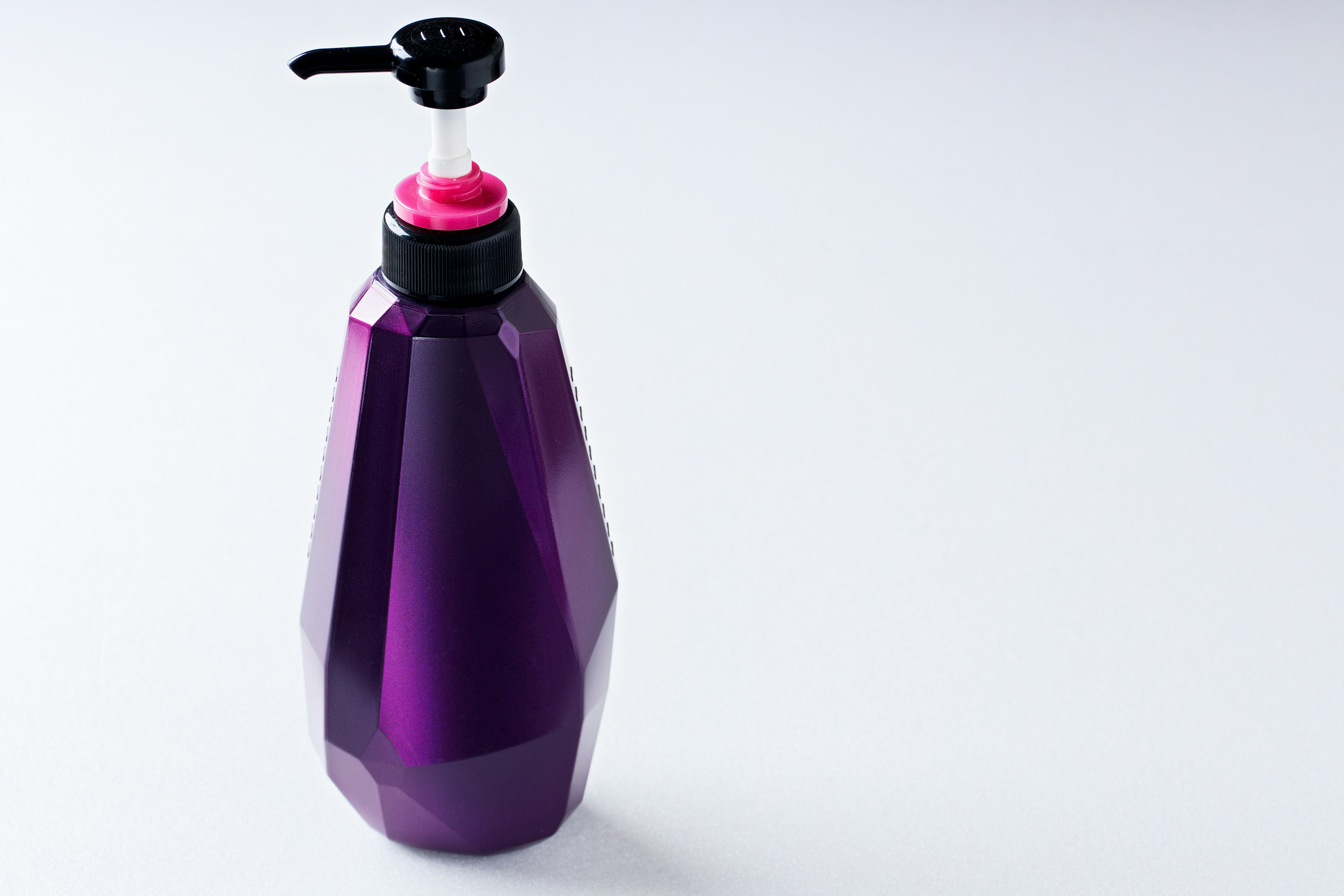 Purple geometric bottle with pink and black pump