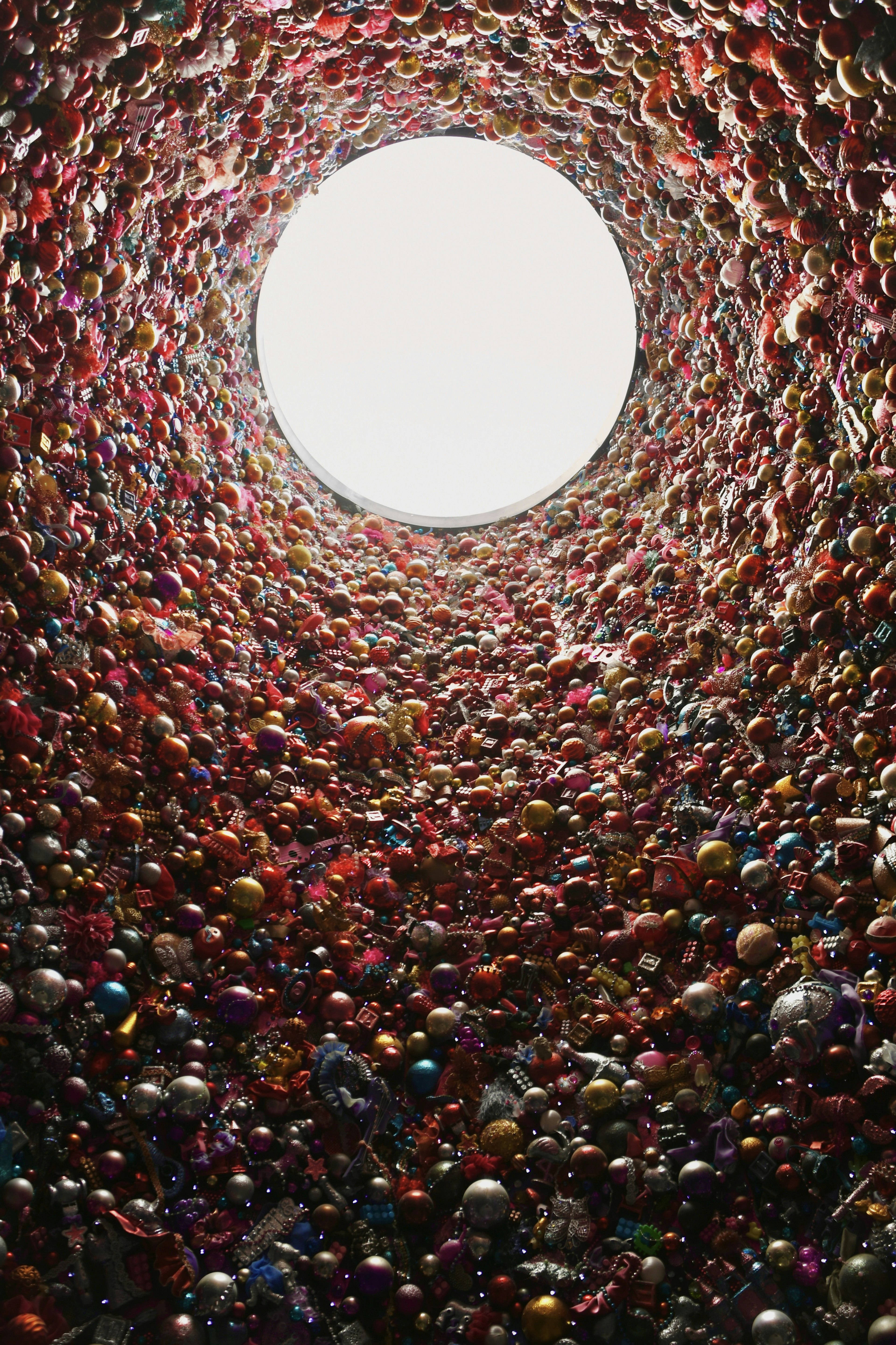 Une structure en forme de tunnel remplie de sphères colorées menant à une lumière brillante