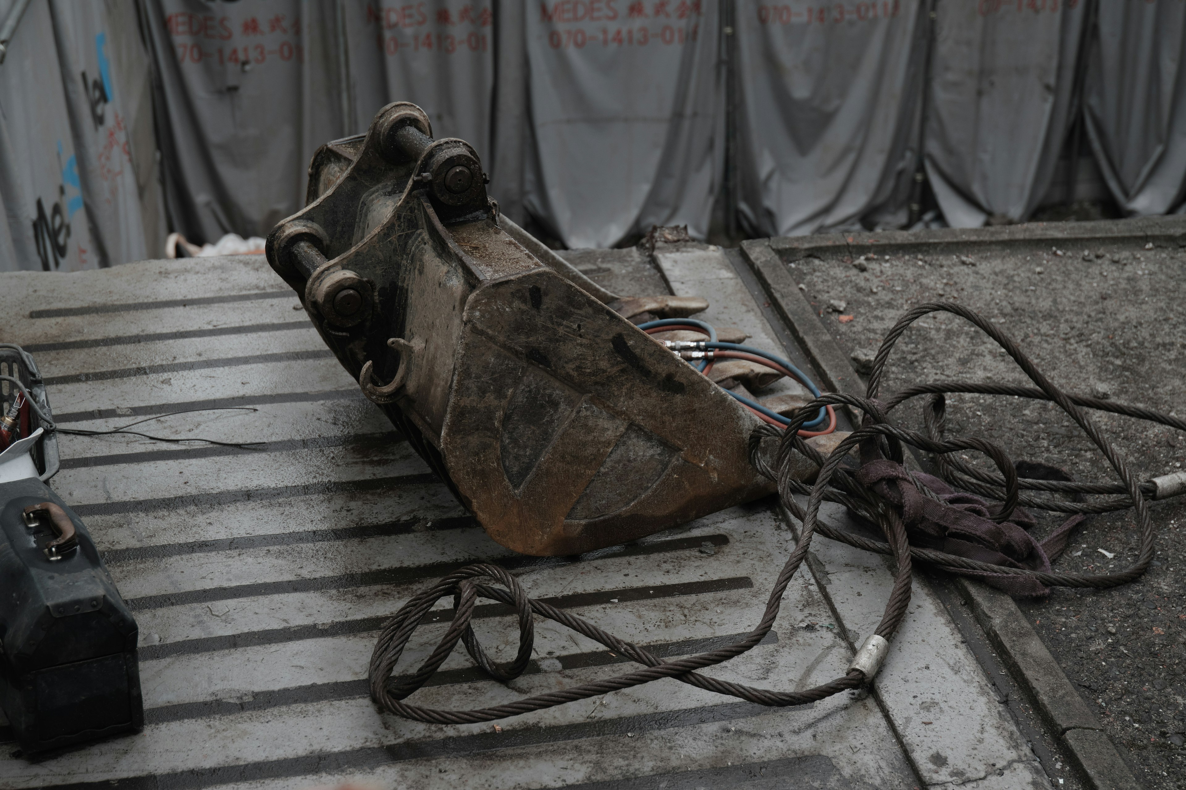 Excavator attachment resting on a construction site surface