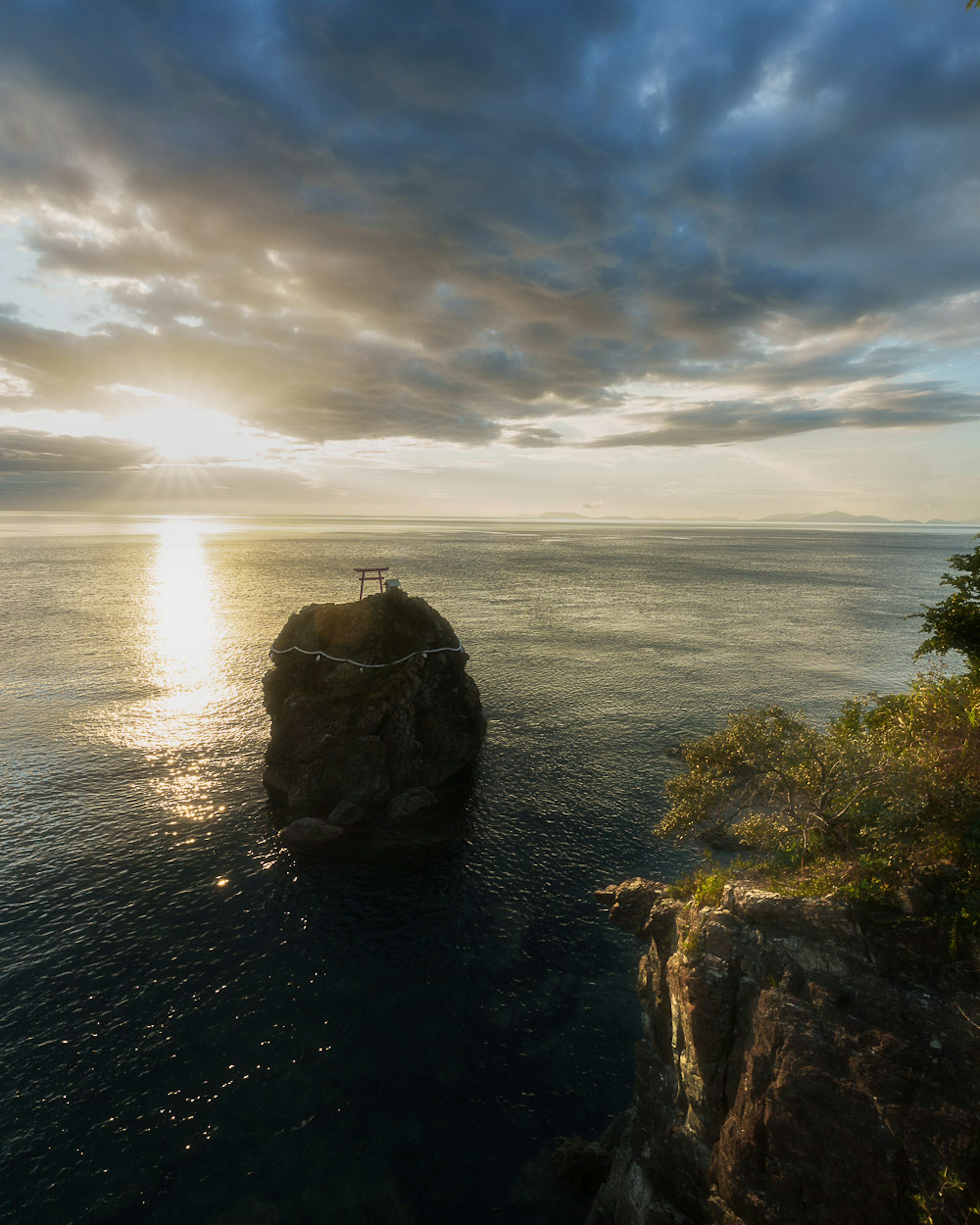 Una vista panoramica di una roccia nel mare con un bellissimo tramonto