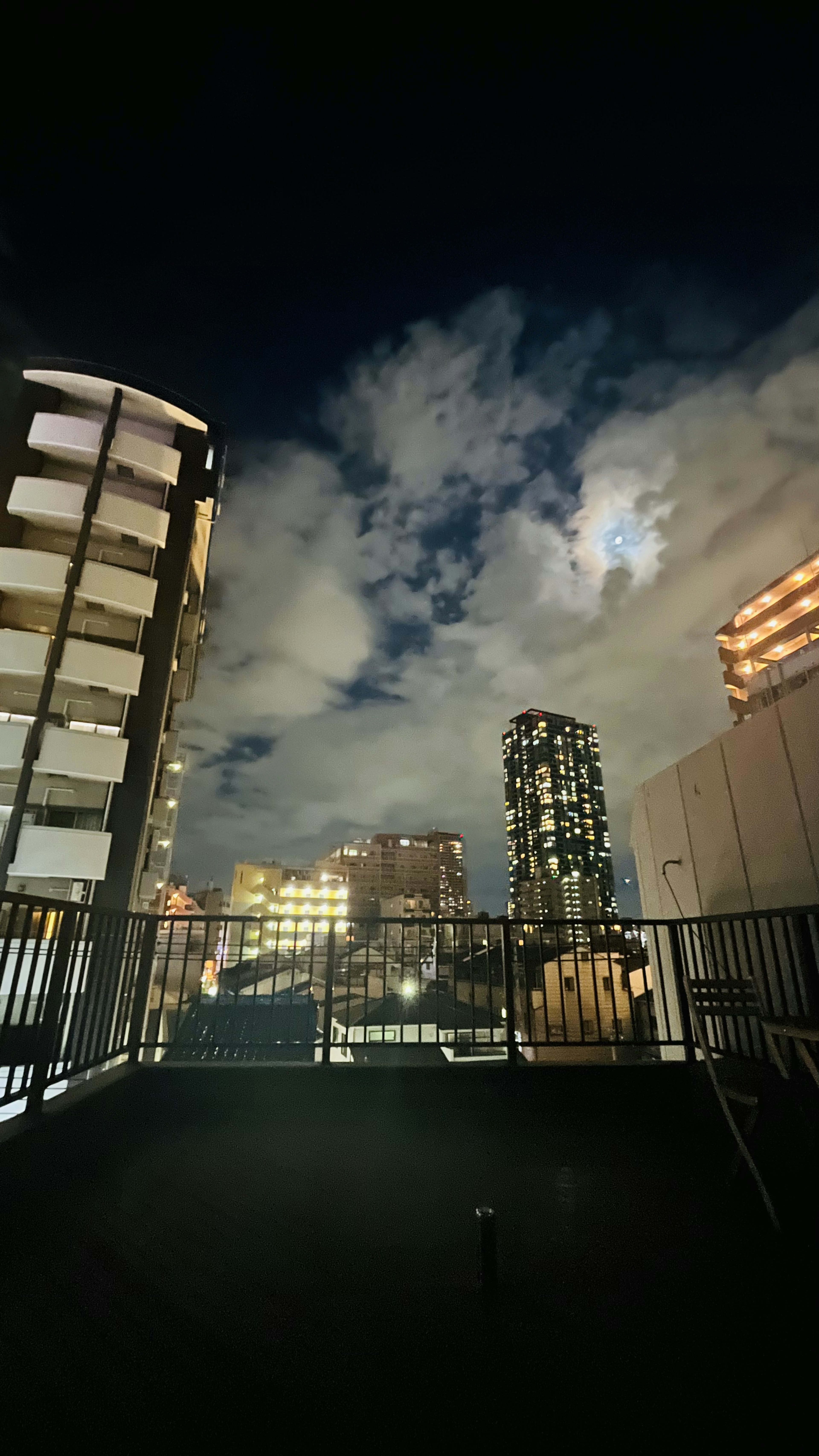 夜の都市の景色、高層ビルと雲、明るい光