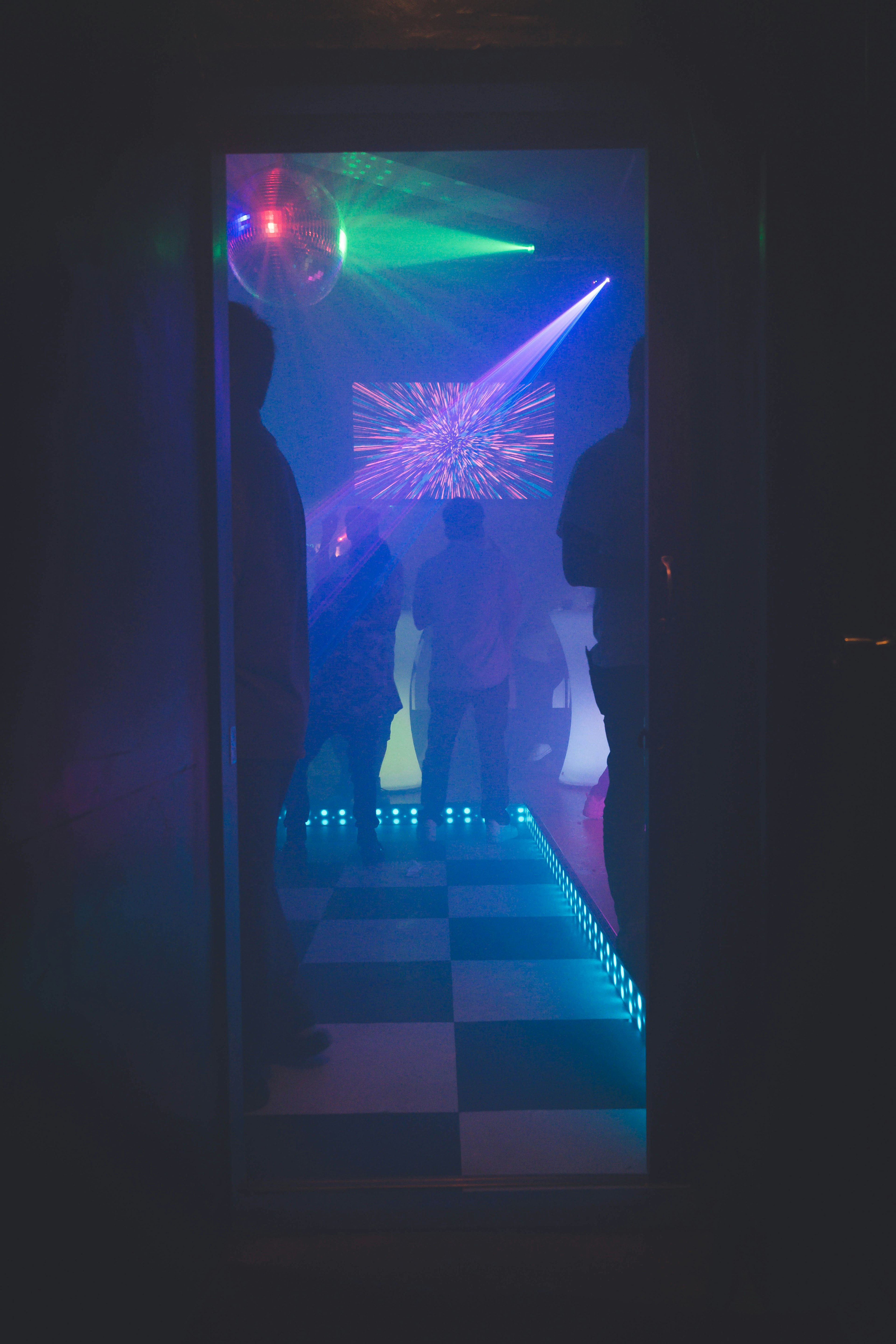 Entrance to a dance floor with colorful laser lights and vibrant illumination