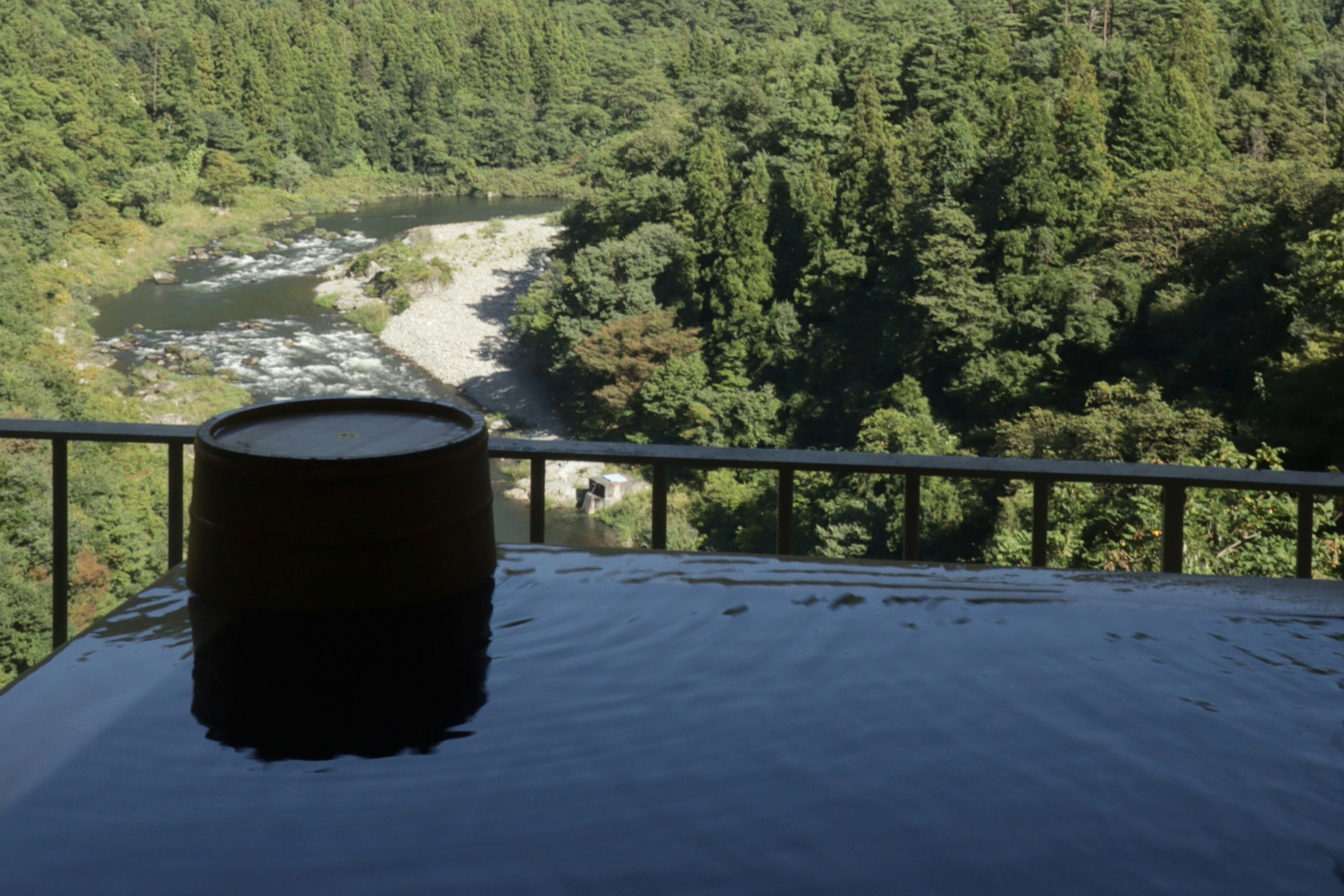 Vista escénica de un manantial caliente con vista a un río y un bosque