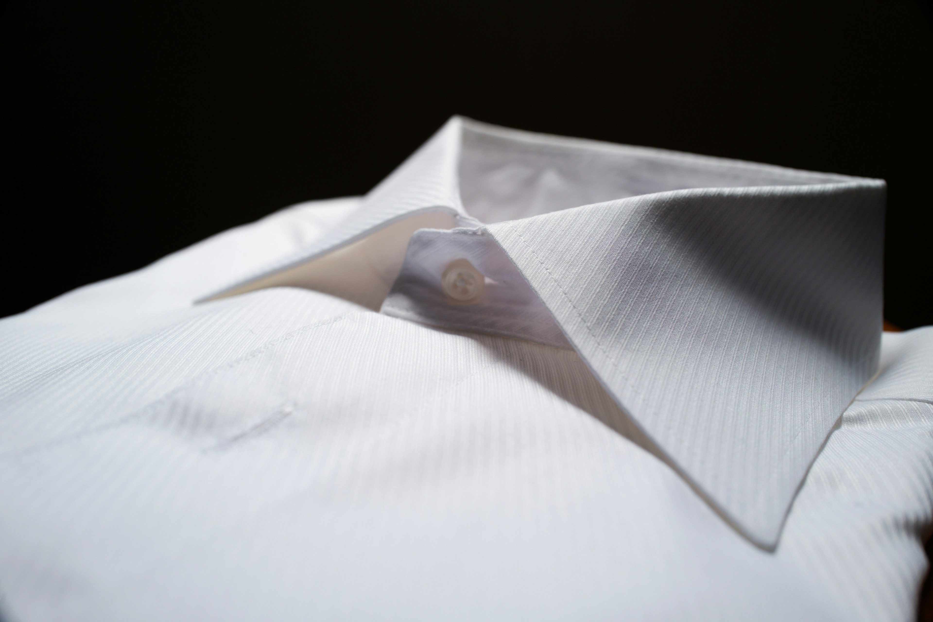 White shirt collar prominently displayed against a dark background