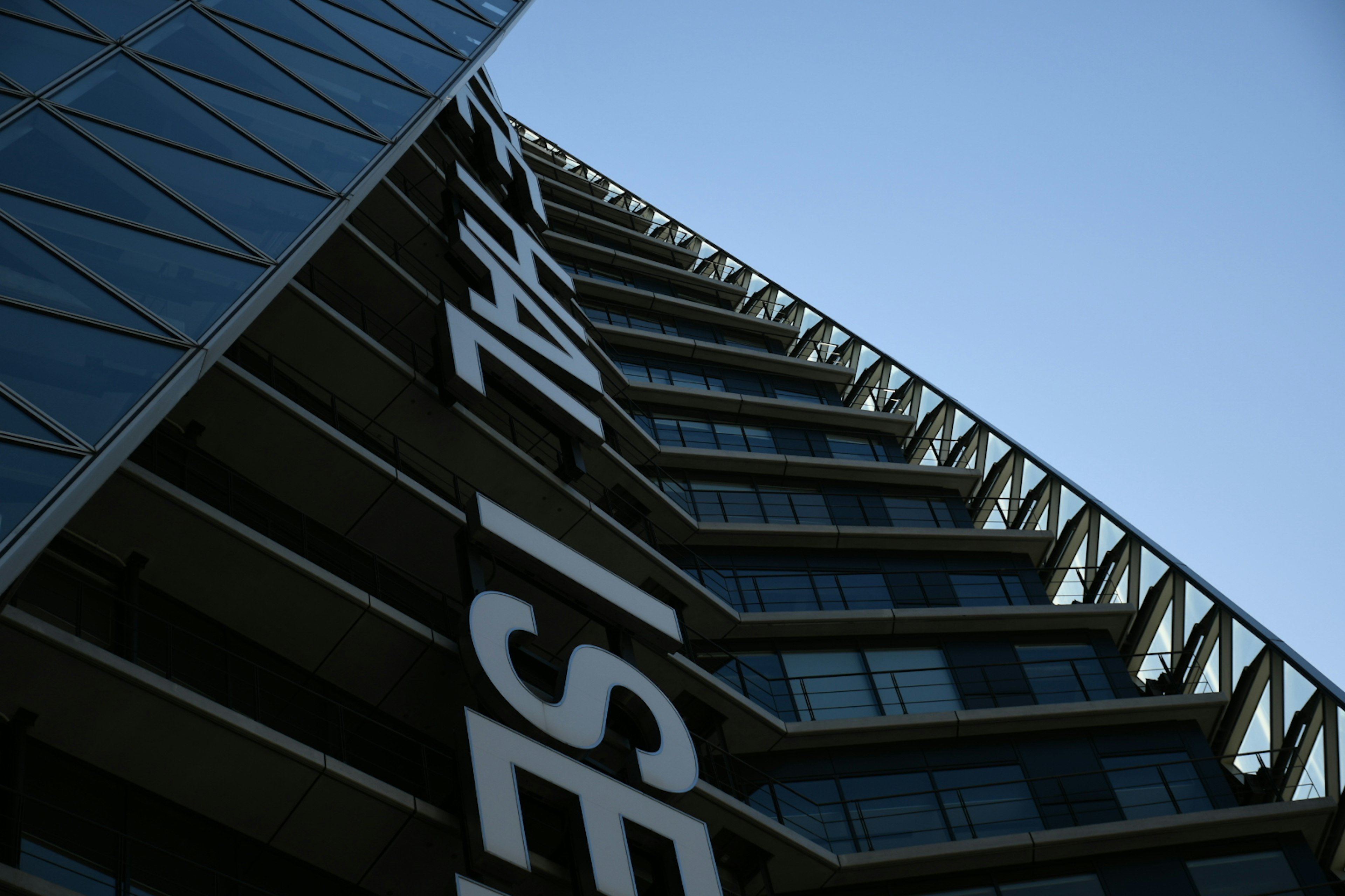 Diagonal view of a modern building with distinctive design against a clear blue sky