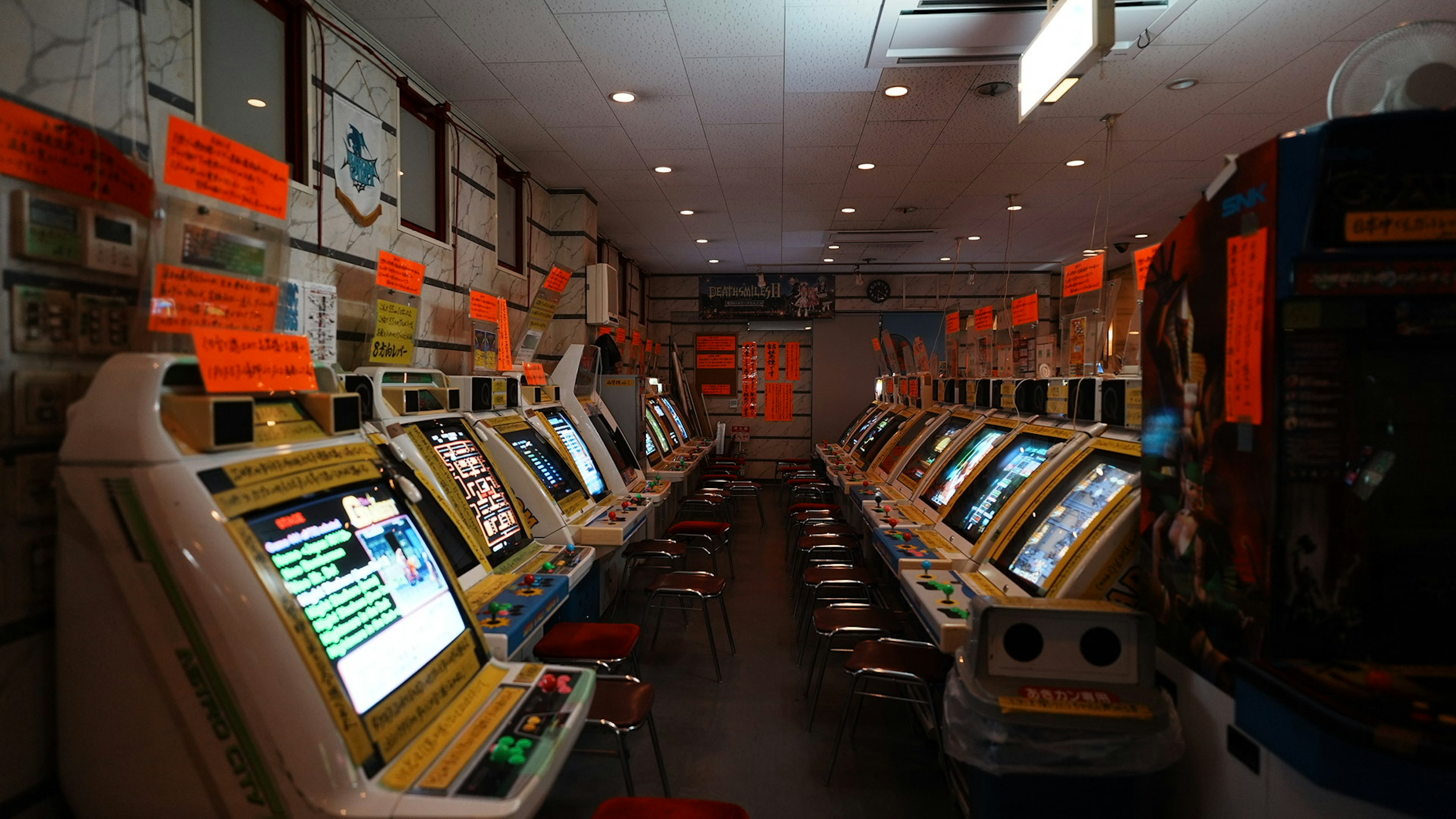 Salle lumineuse remplie de machines à sous avec des étiquettes orange