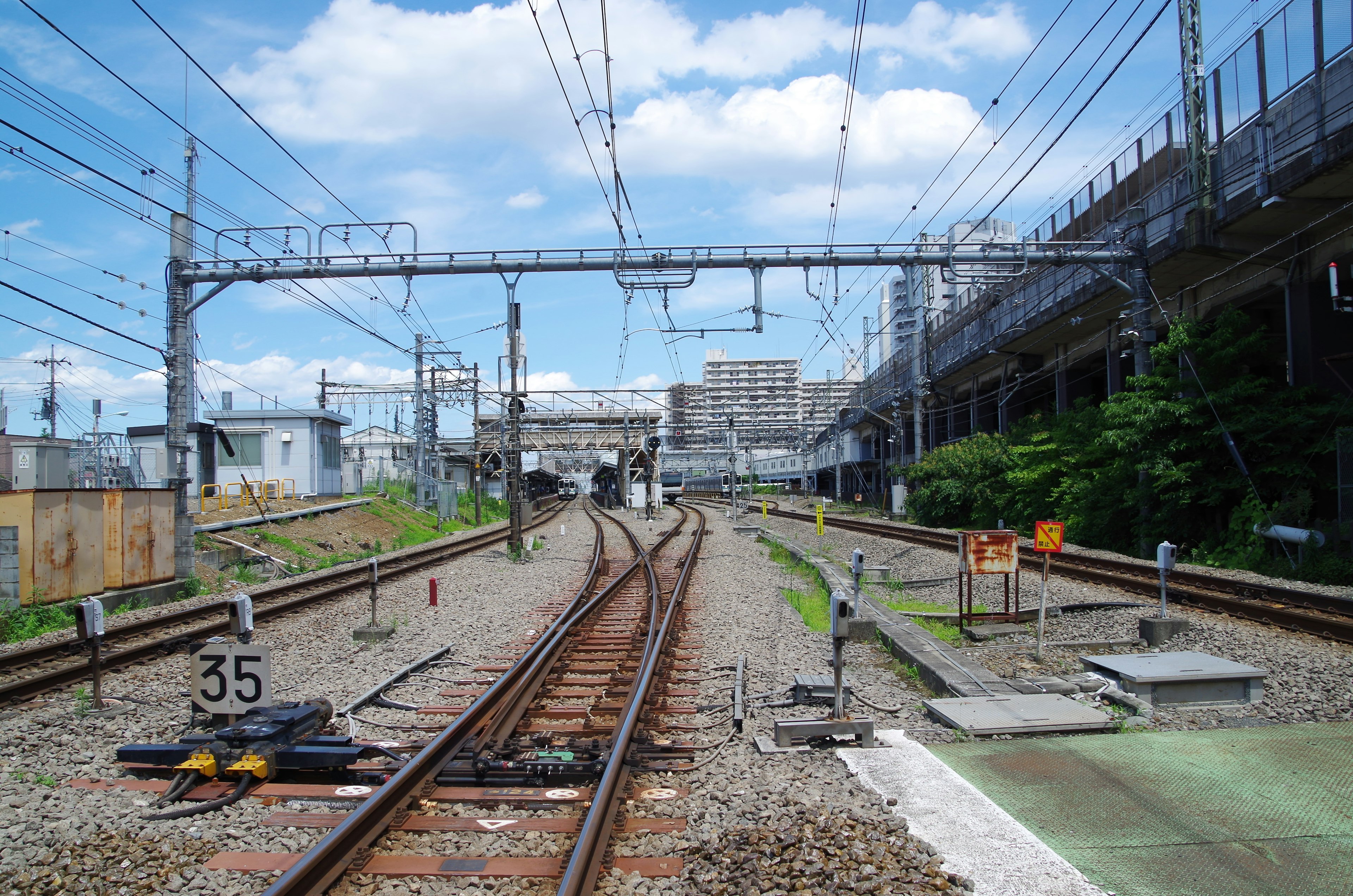 A view of diverging railway tracks with surrounding buildings and signal posts