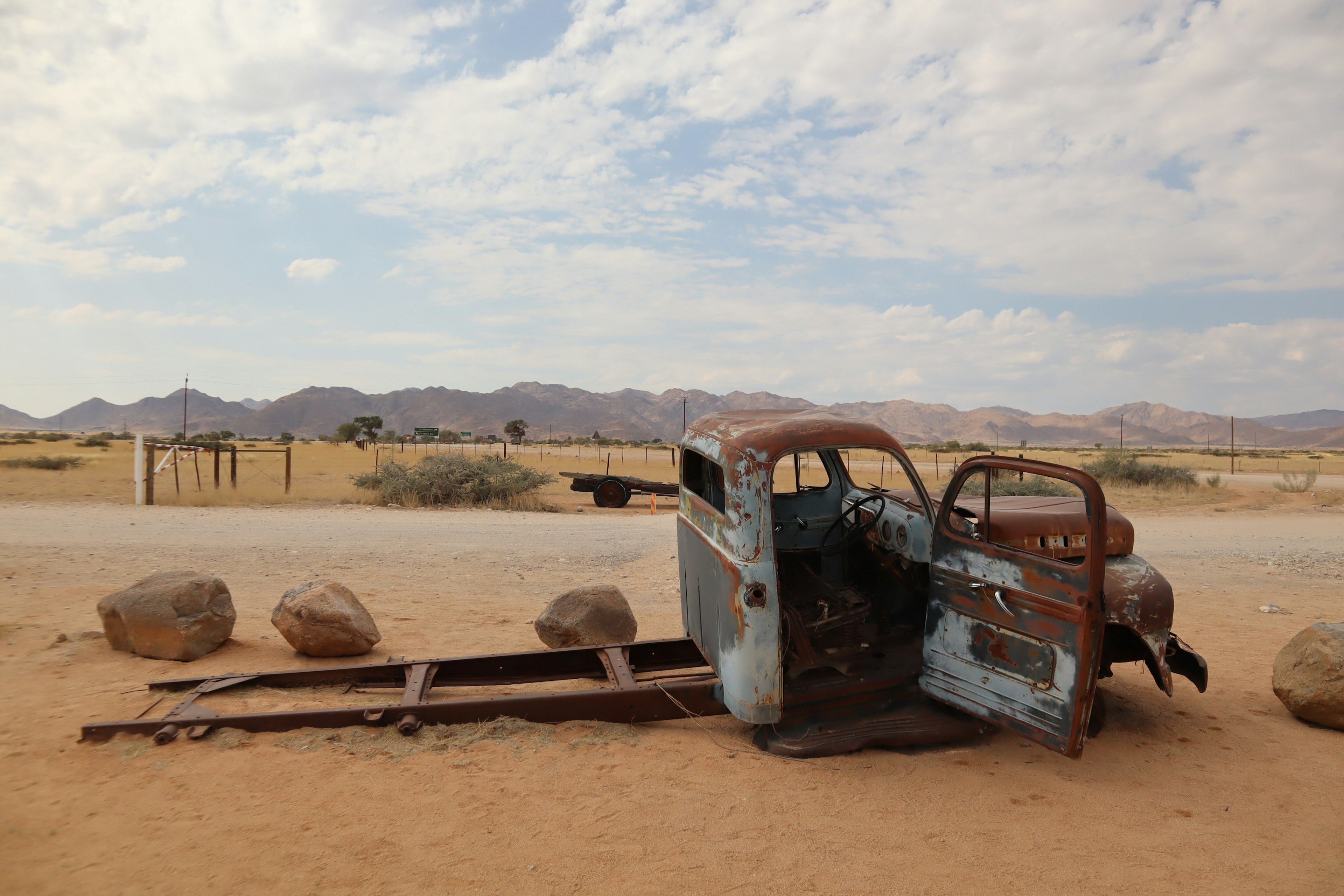 Old truck body in a desert landscape with stones and mountains