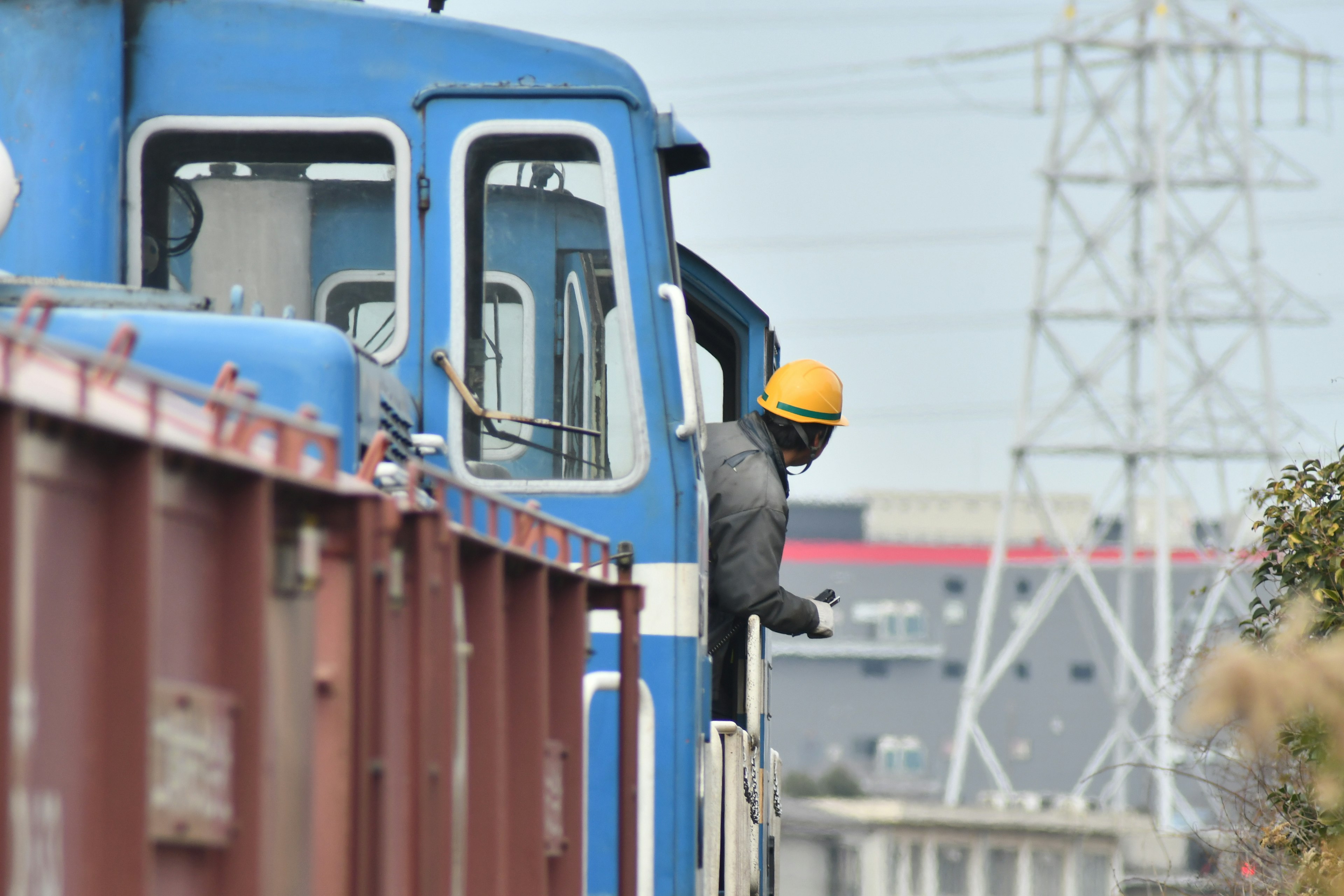 Image d'une locomotive bleue avec un conducteur de train portant un casque jaune