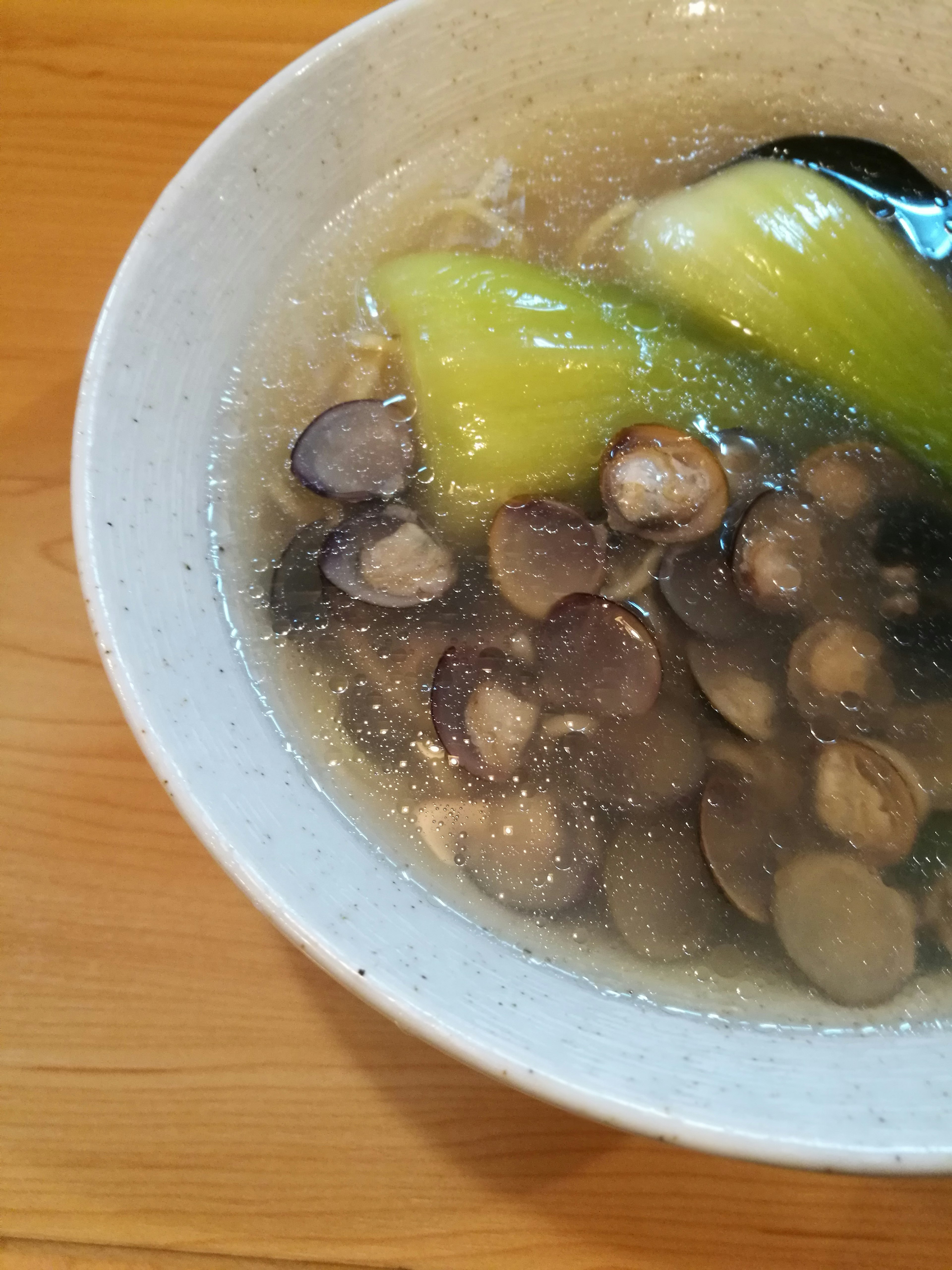 Soupe claire avec des champignons tranchés et des légumes verts