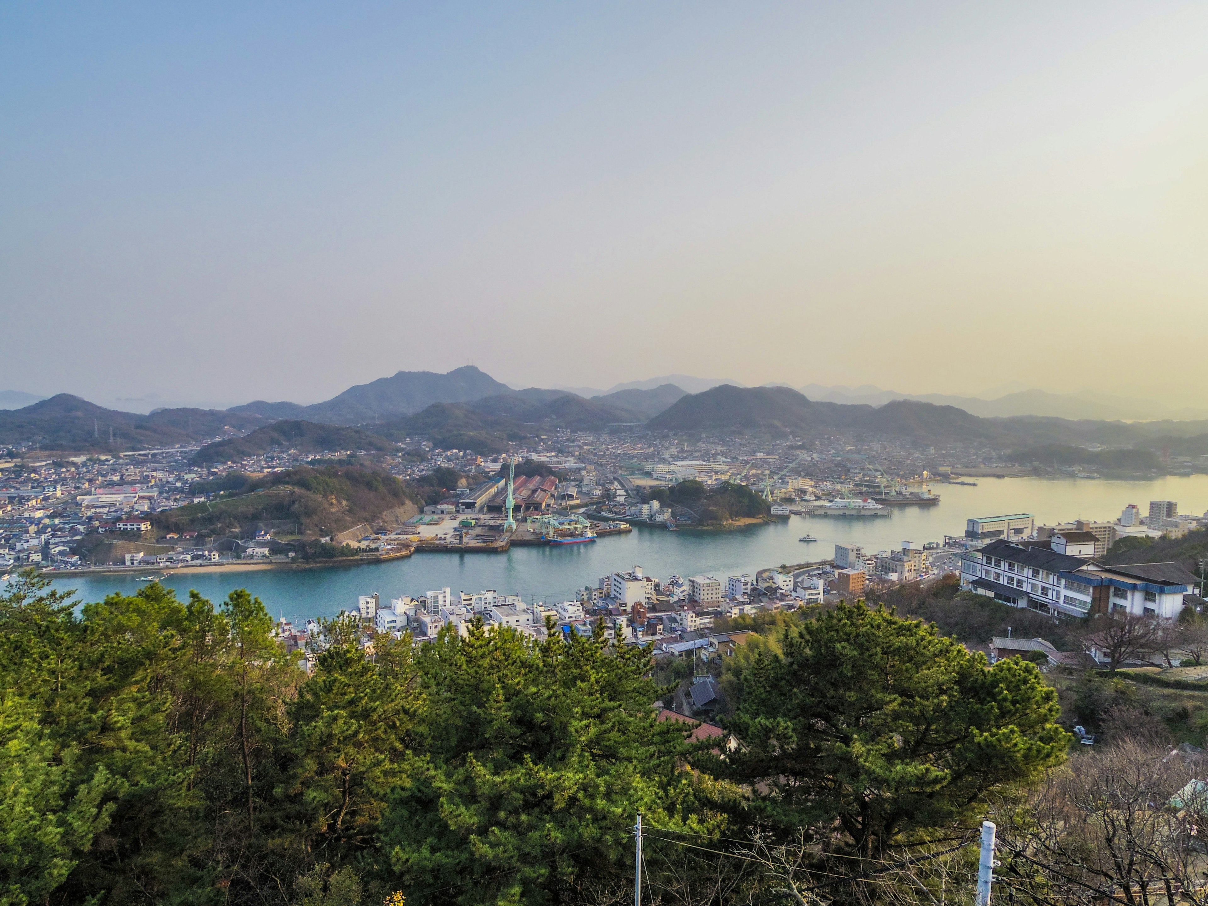 Vue panoramique d'une ville côtière entourée de verdure et de collines