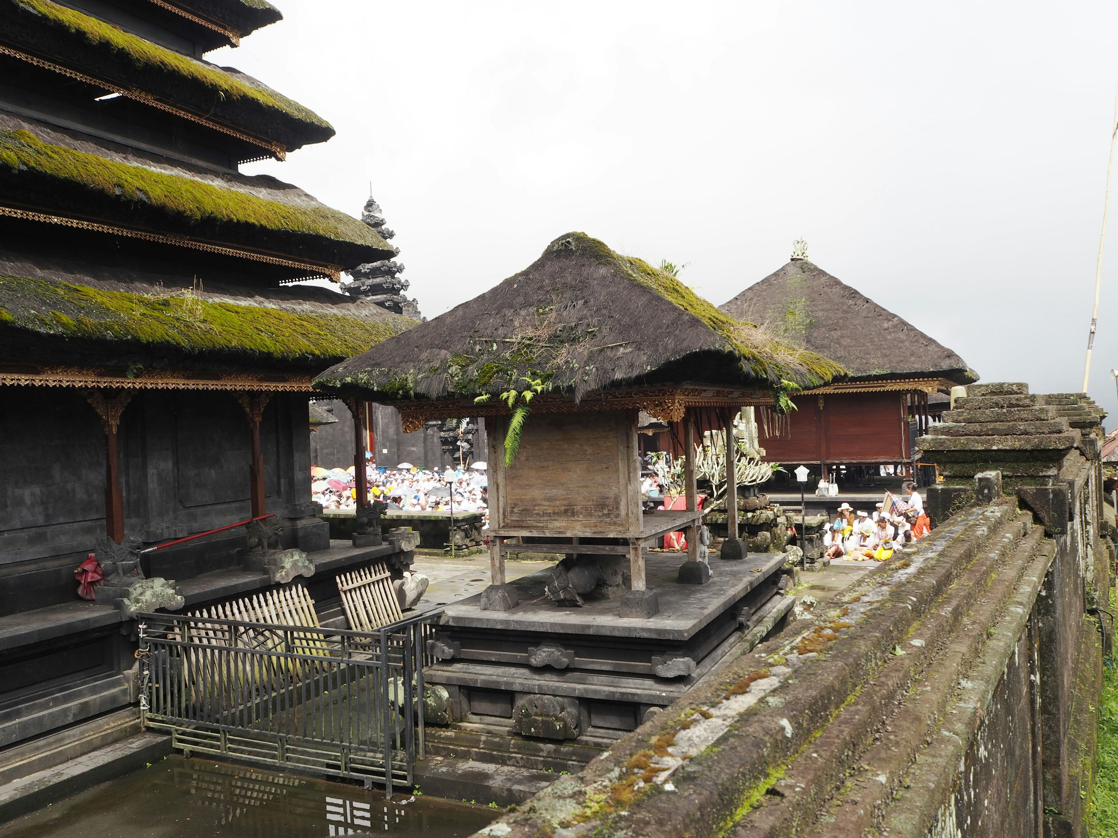 Scenic view of a Balinese temple featuring moss-covered roofs and stone structures