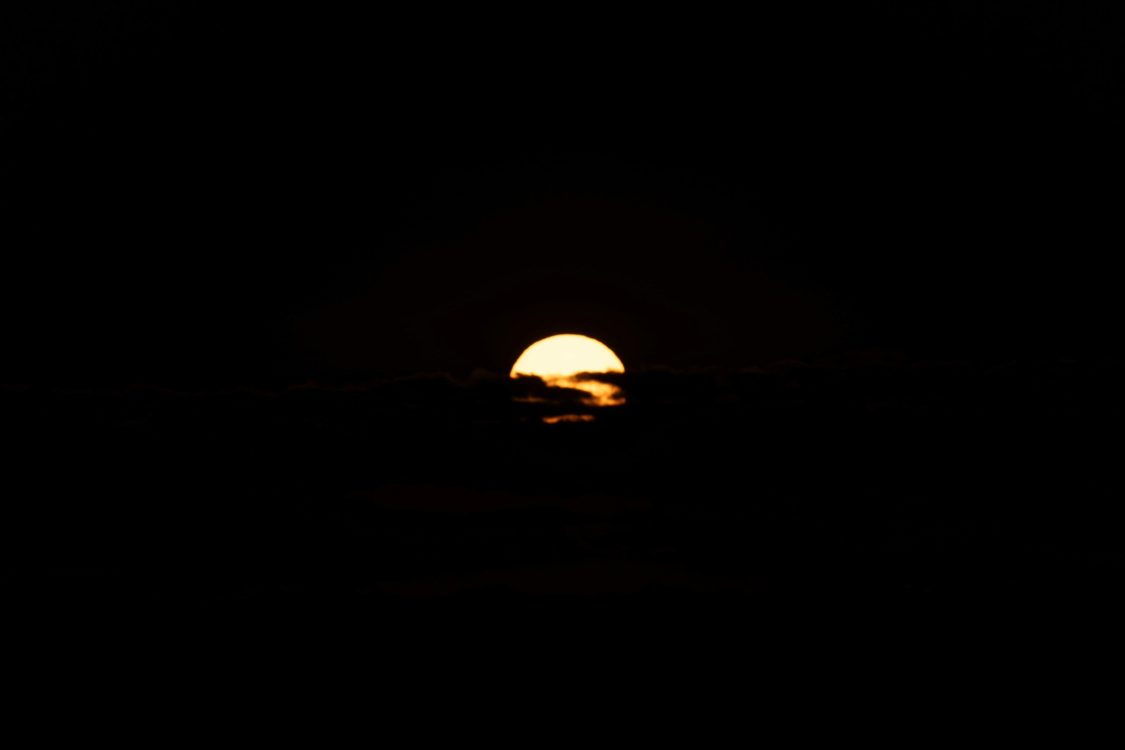 暗い背景に浮かぶ夕日のシルエット