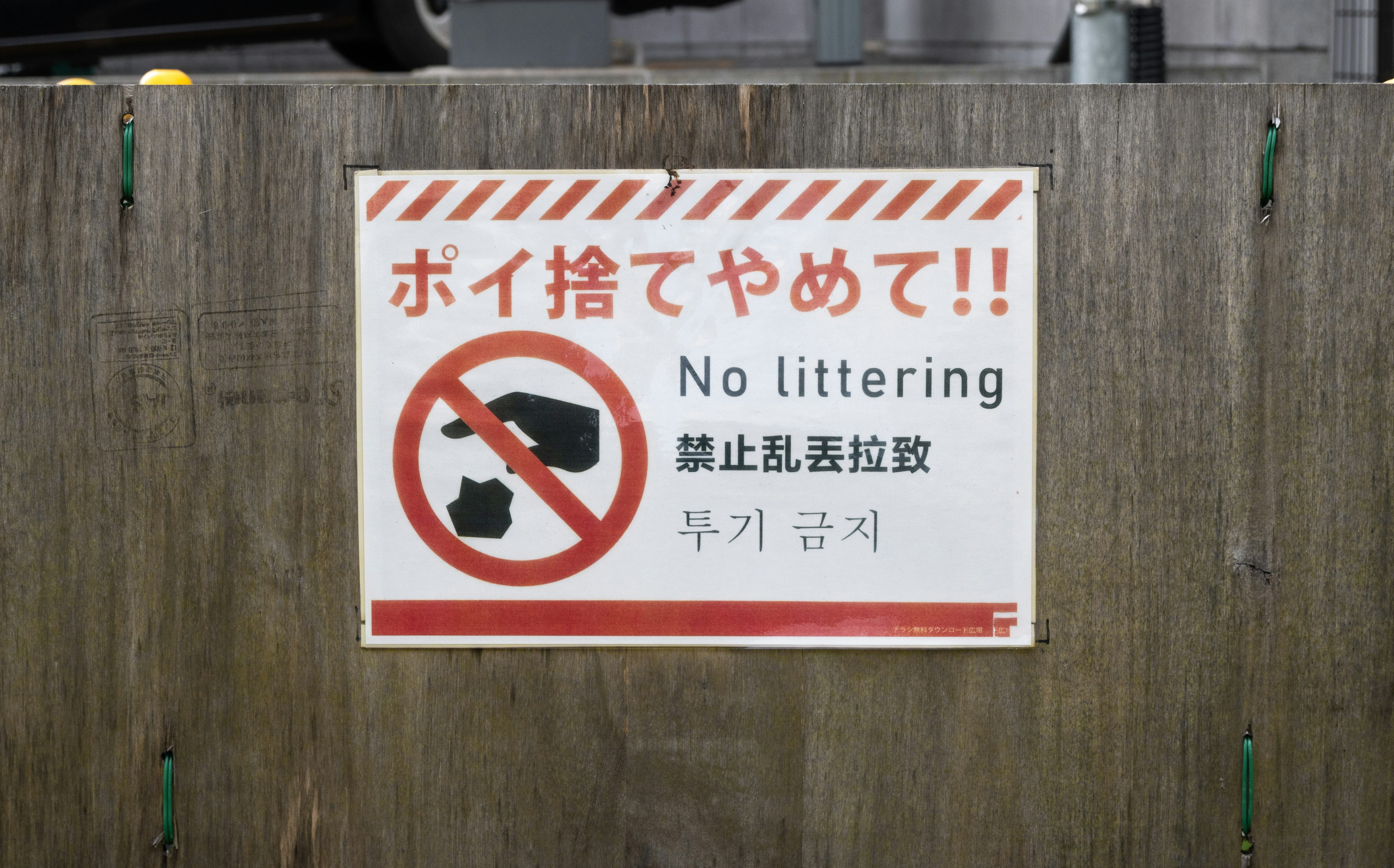 Sign prohibiting littering displayed on a wooden wall