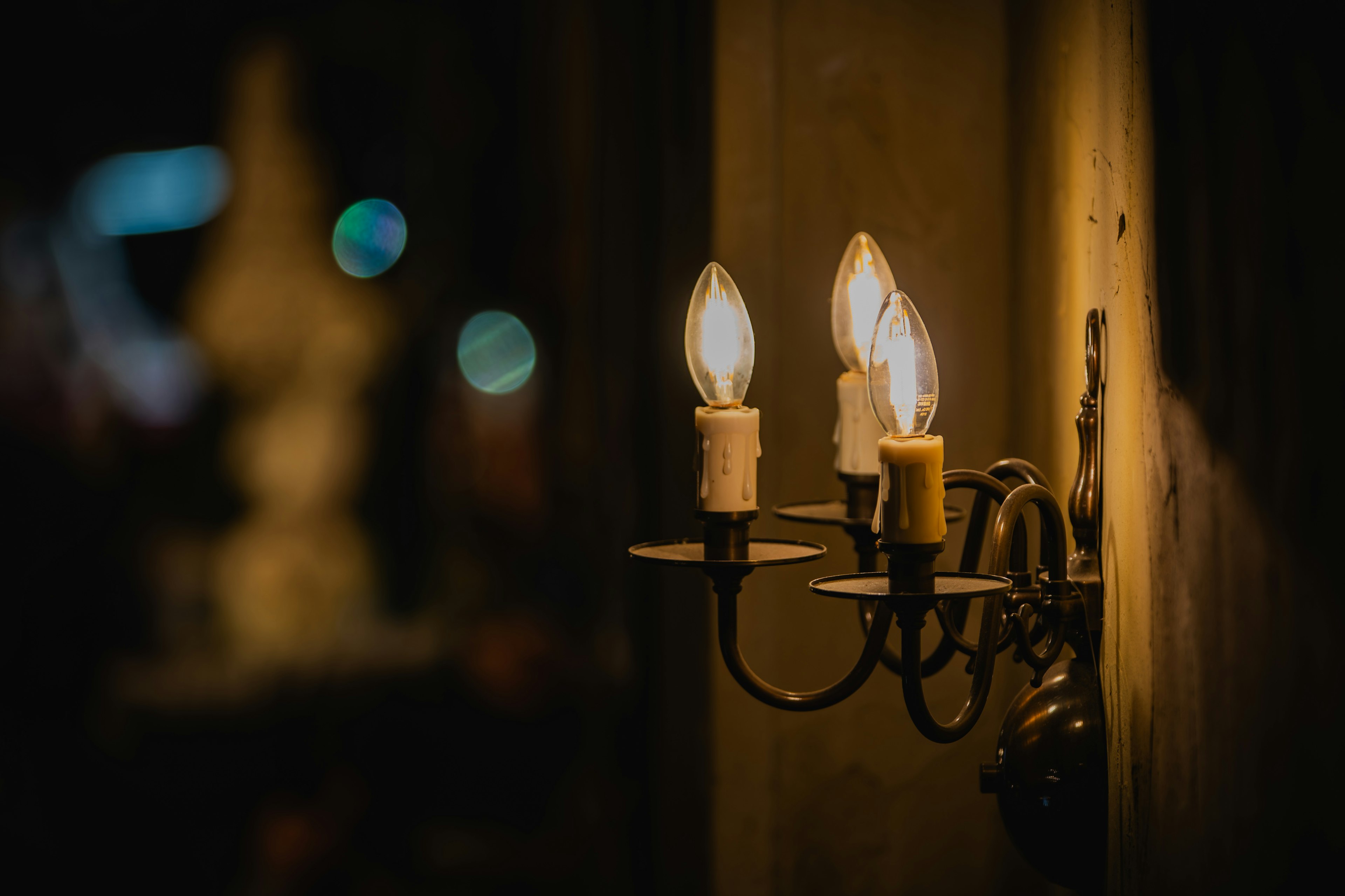 Chandelier dinding dengan bola lampu menyerupai lilin