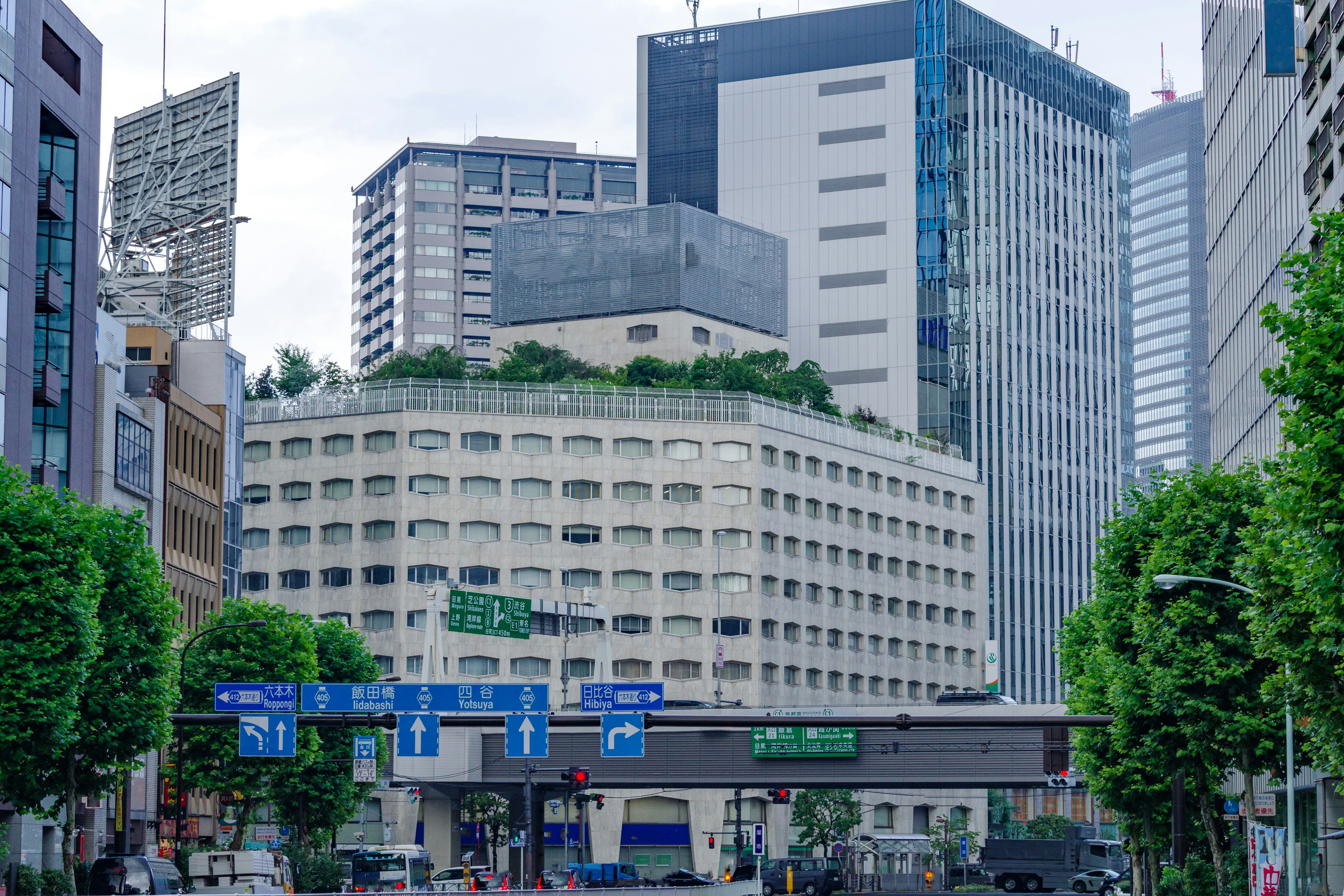 Unique building with green rooftop surrounded by skyscrapers