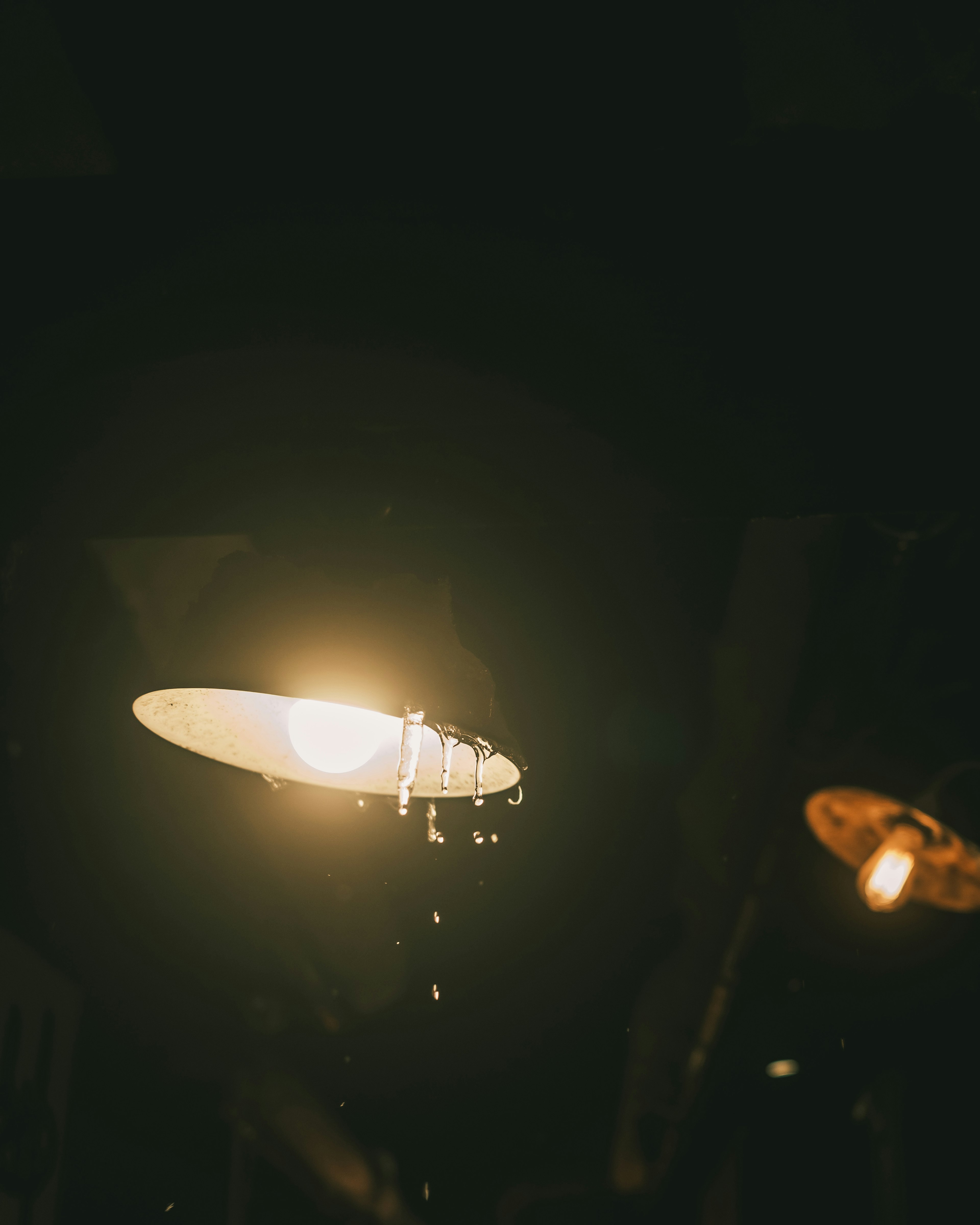 Una lámpara brillante con gotas de agua en un fondo oscuro