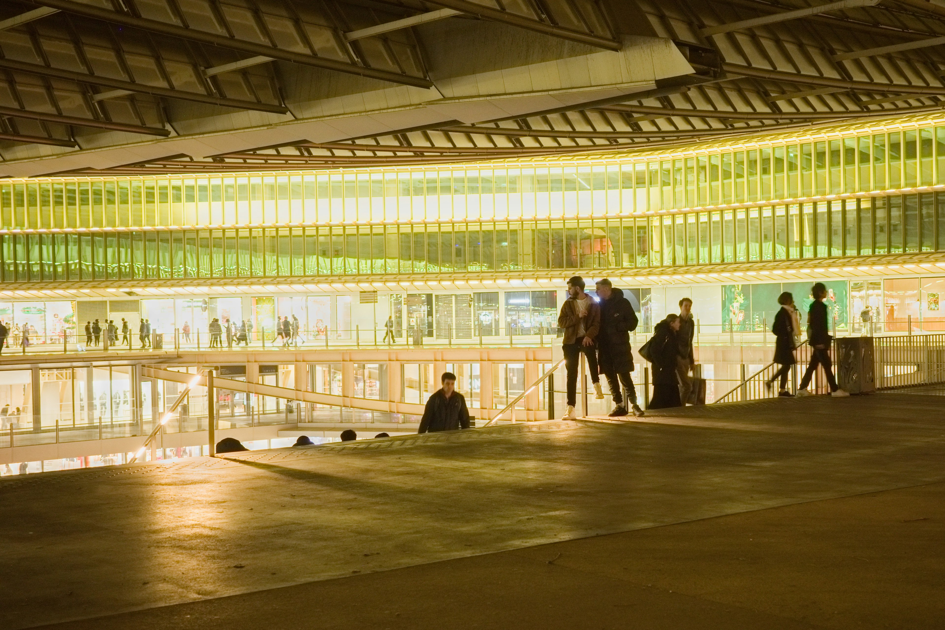 Interior de un edificio moderno con paredes verdes brillantes y personas caminando