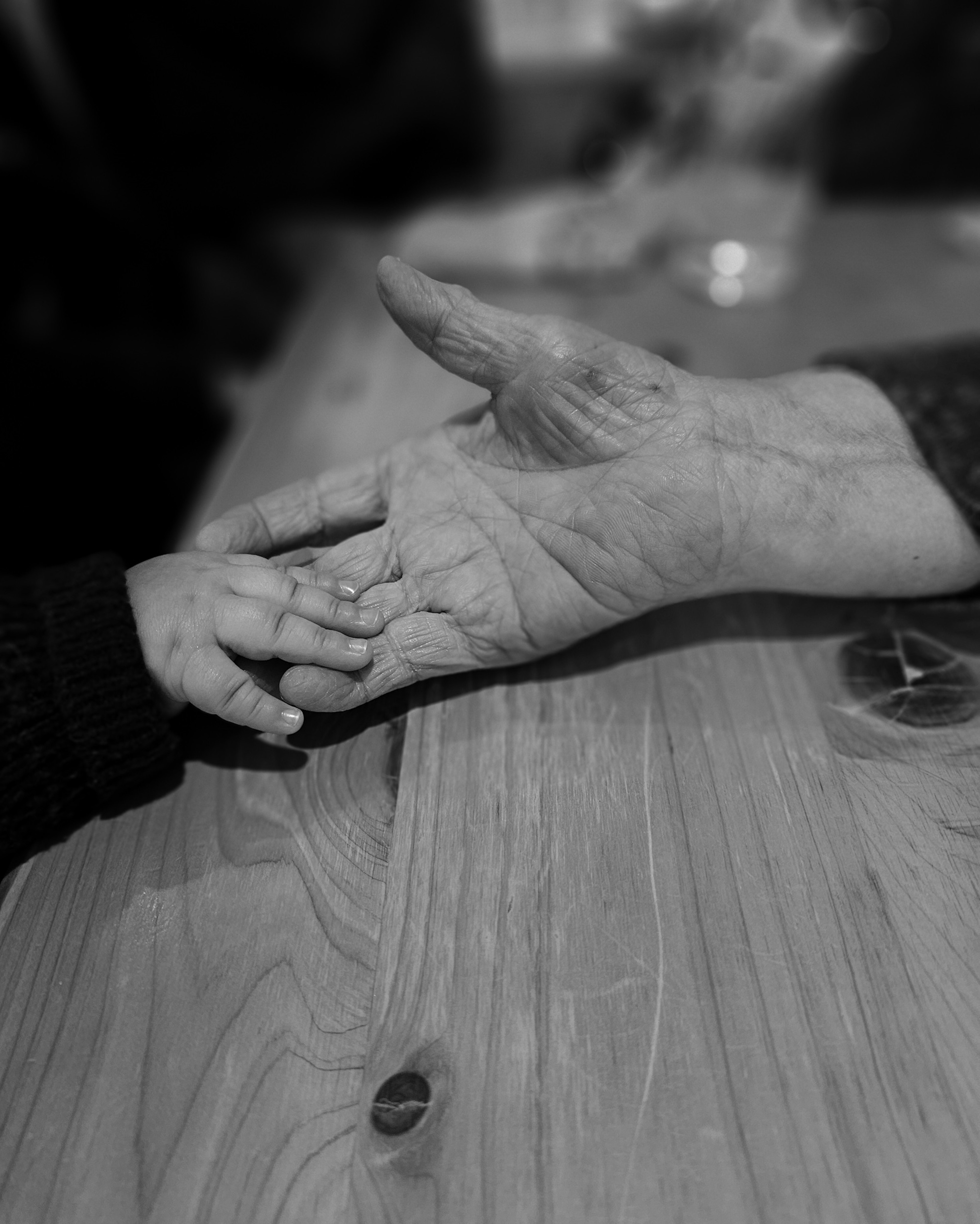 A child's hand gently resting on an elderly person's hand