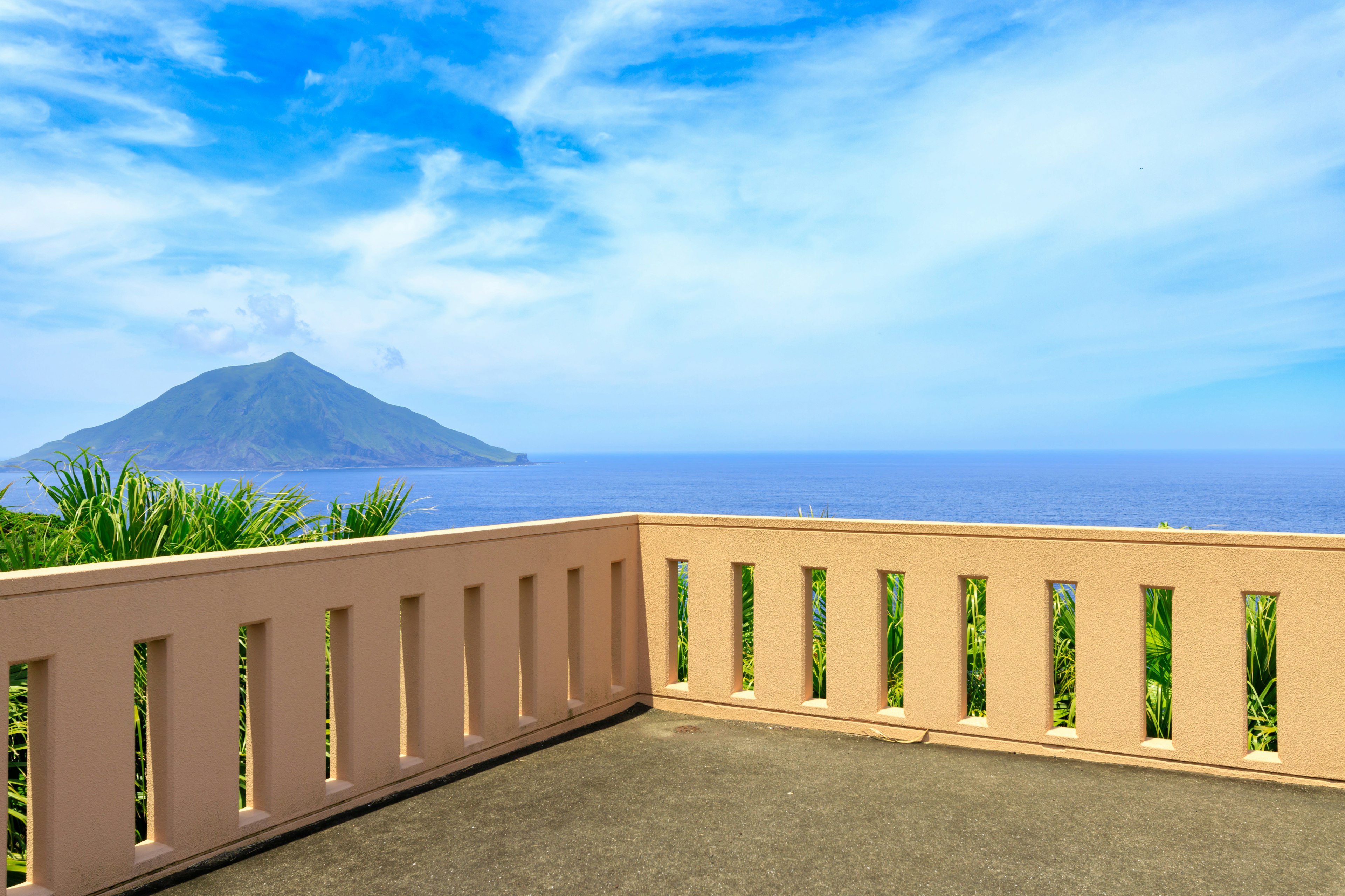 Balcone con vista sull'oceano e una montagna sullo sfondo