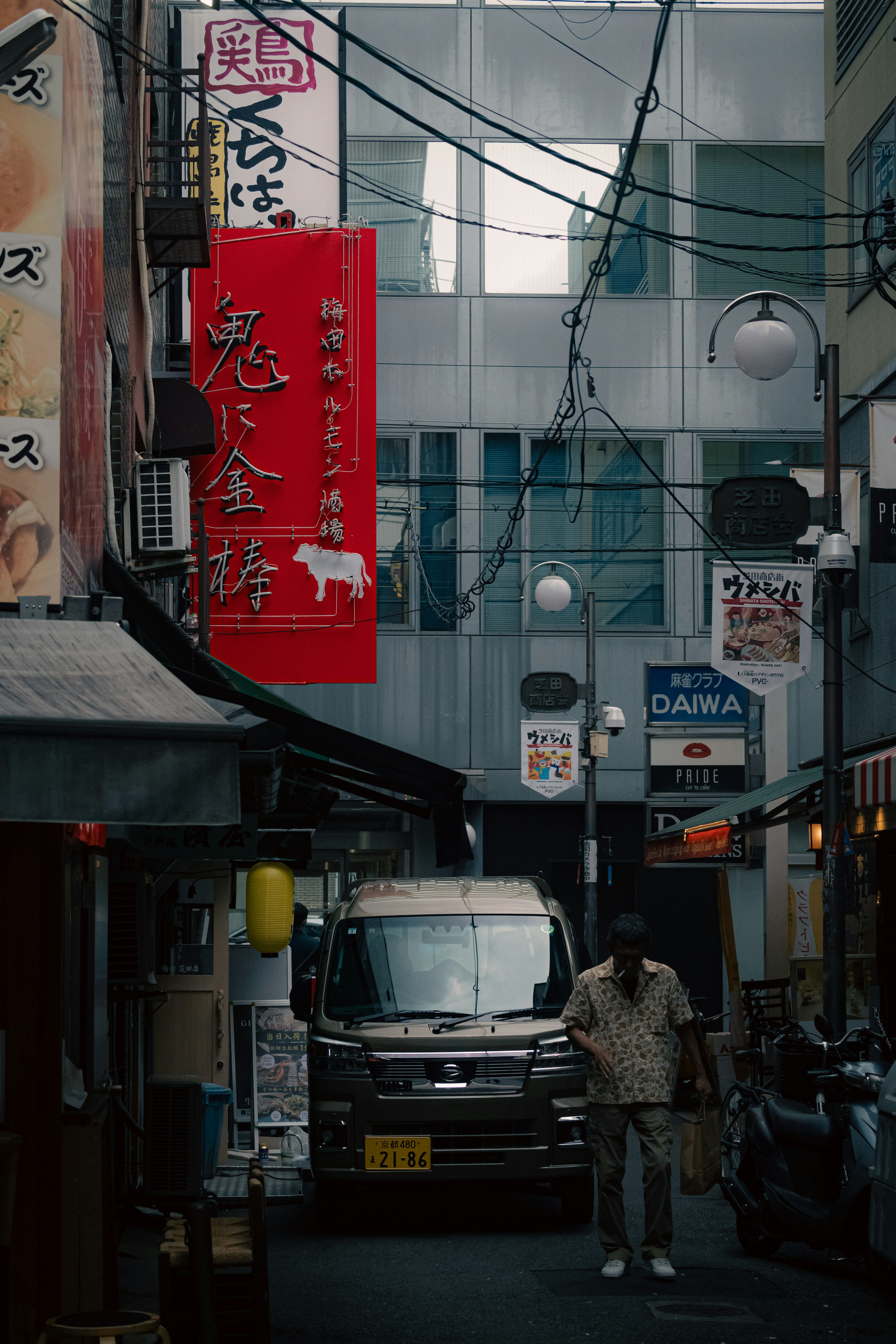 一个男人站在狭窄的巷子里，周围有独特的招牌，展现日本街景