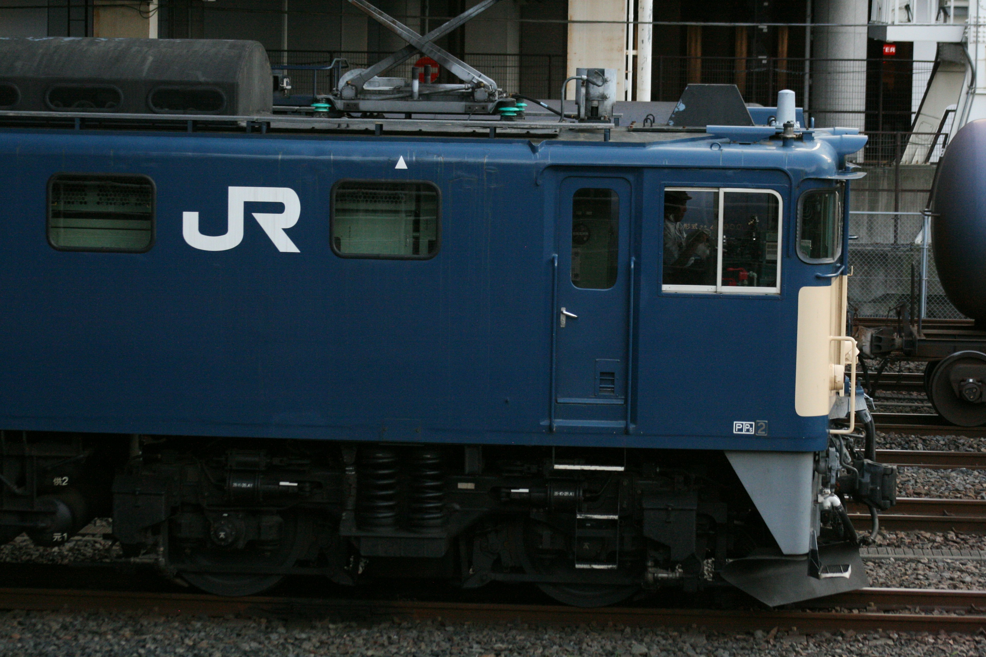 Side view of a blue JR locomotive parked on railway tracks