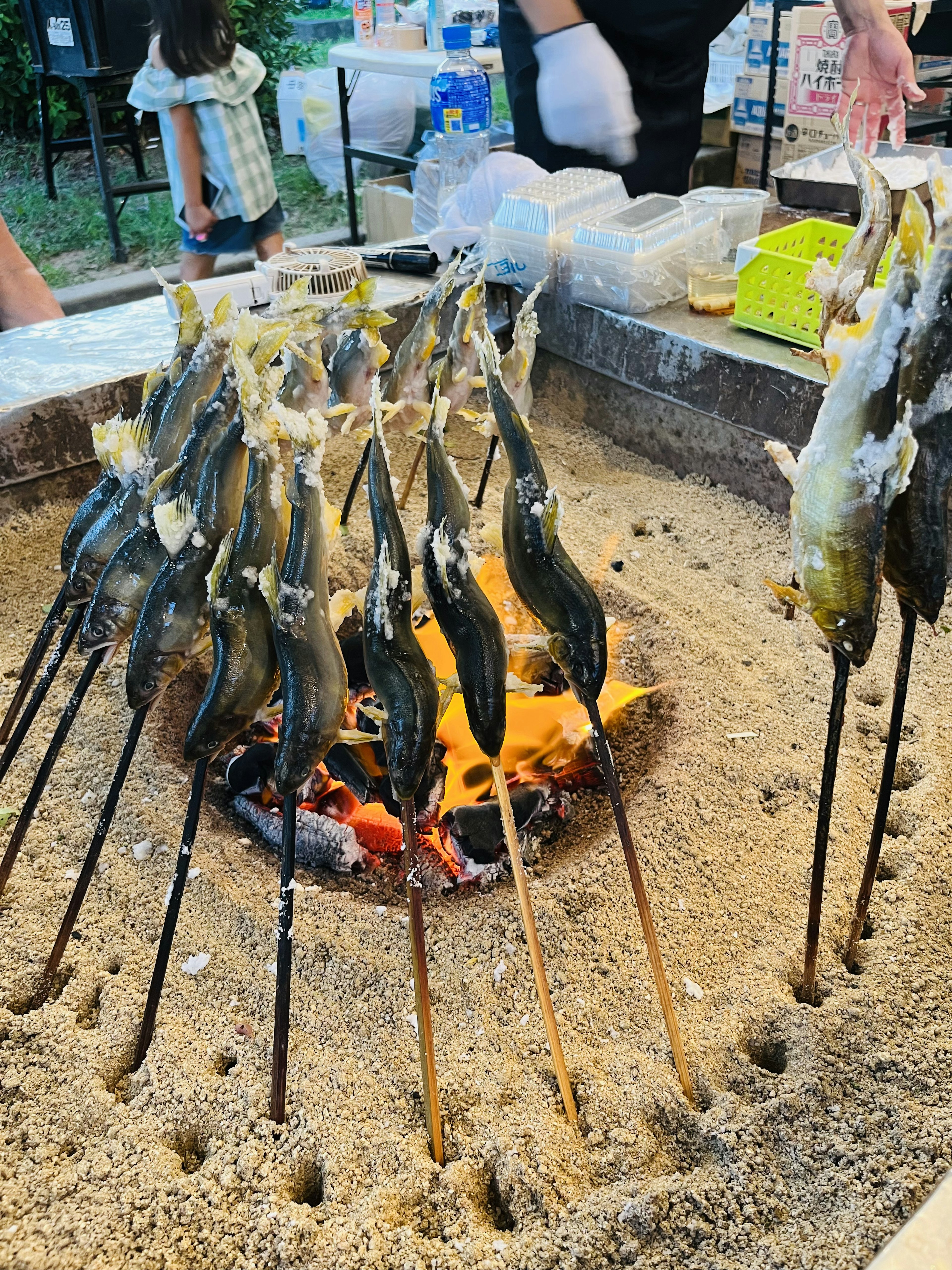 Poissons sur des brochettes rôtis sur un feu ouvert dans un cadre extérieur