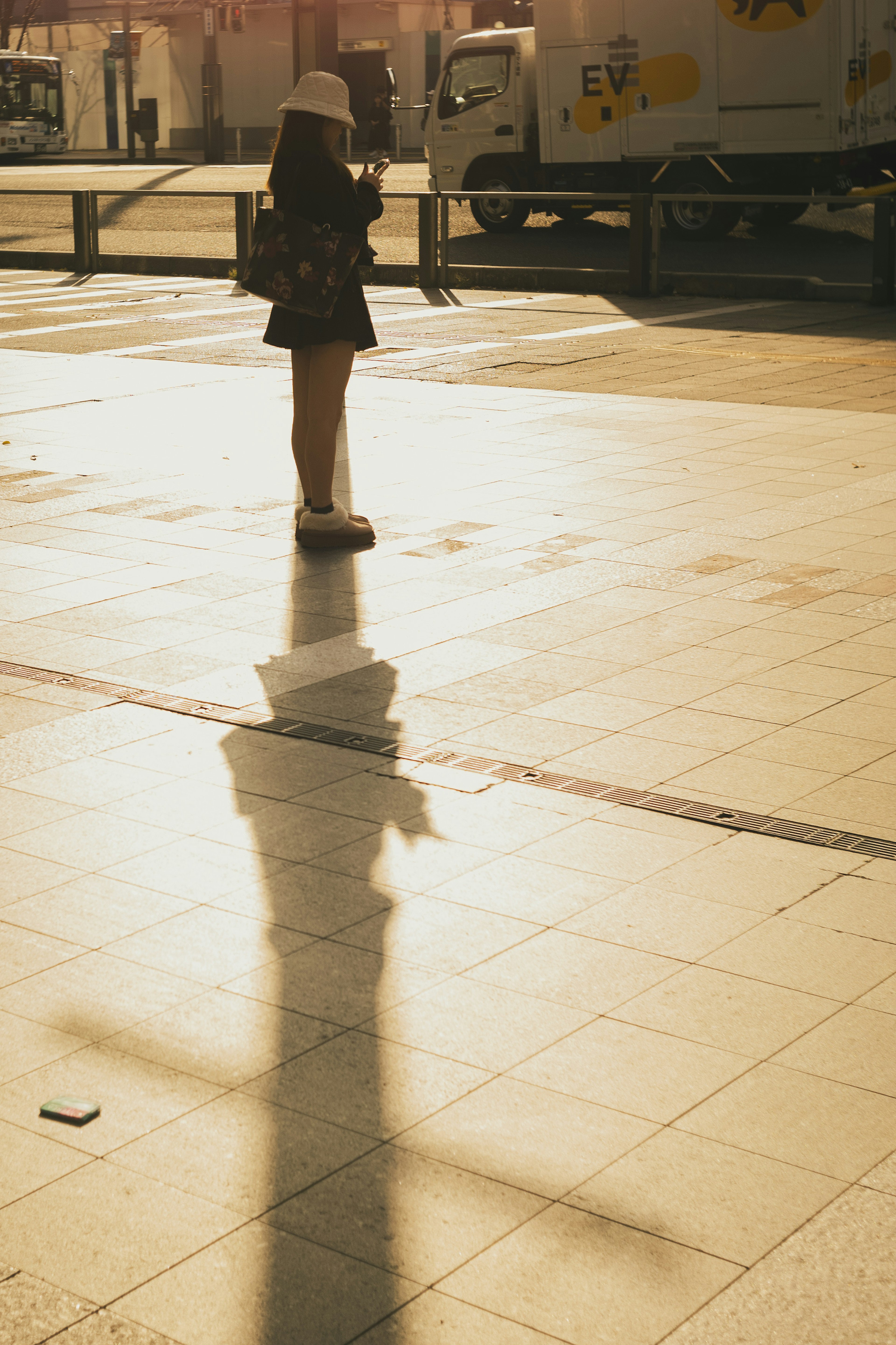 女性が影を落とす街角の風景