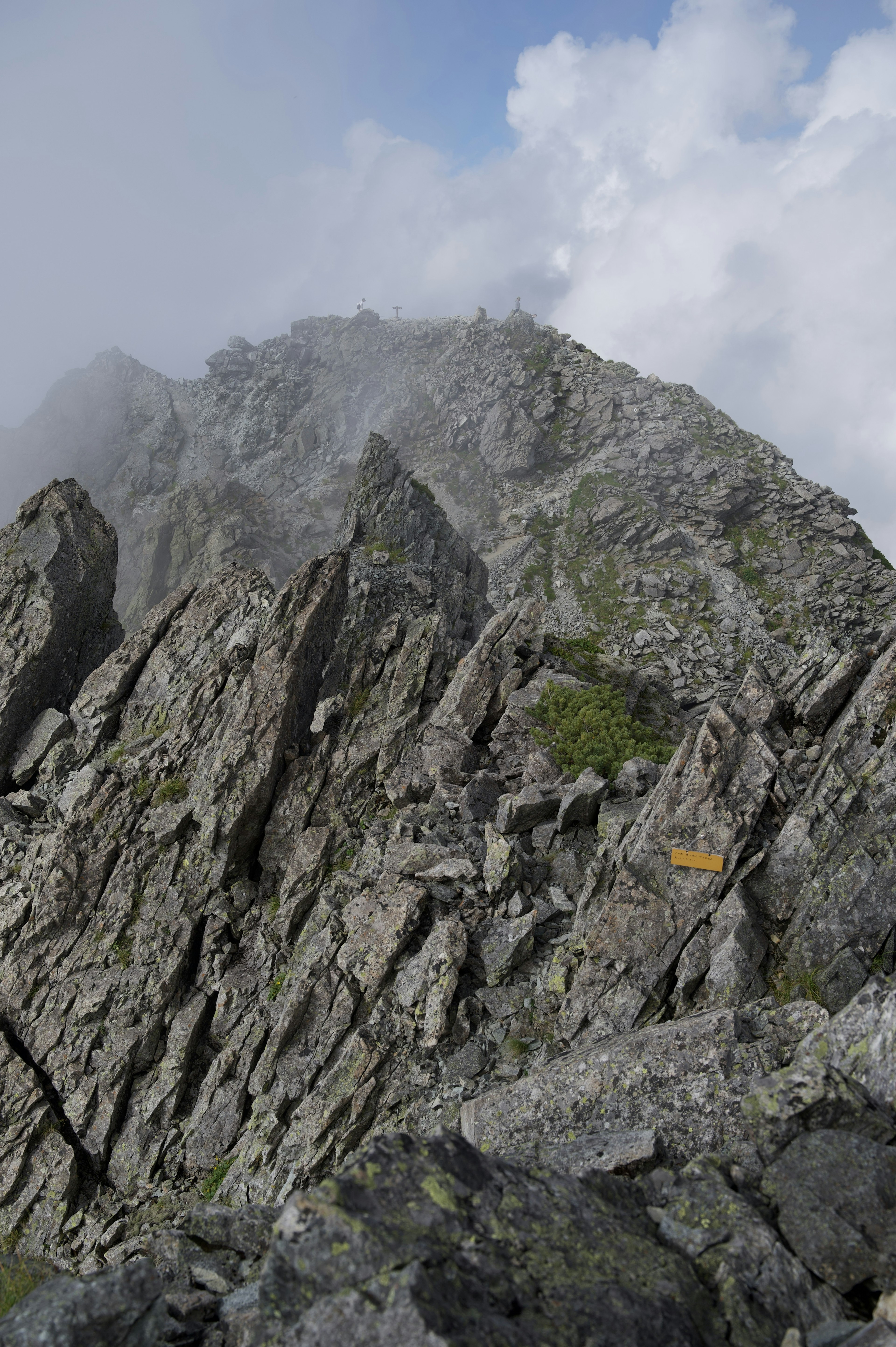 Rugged mountain landscape with cloudy background bright yellow marker visible