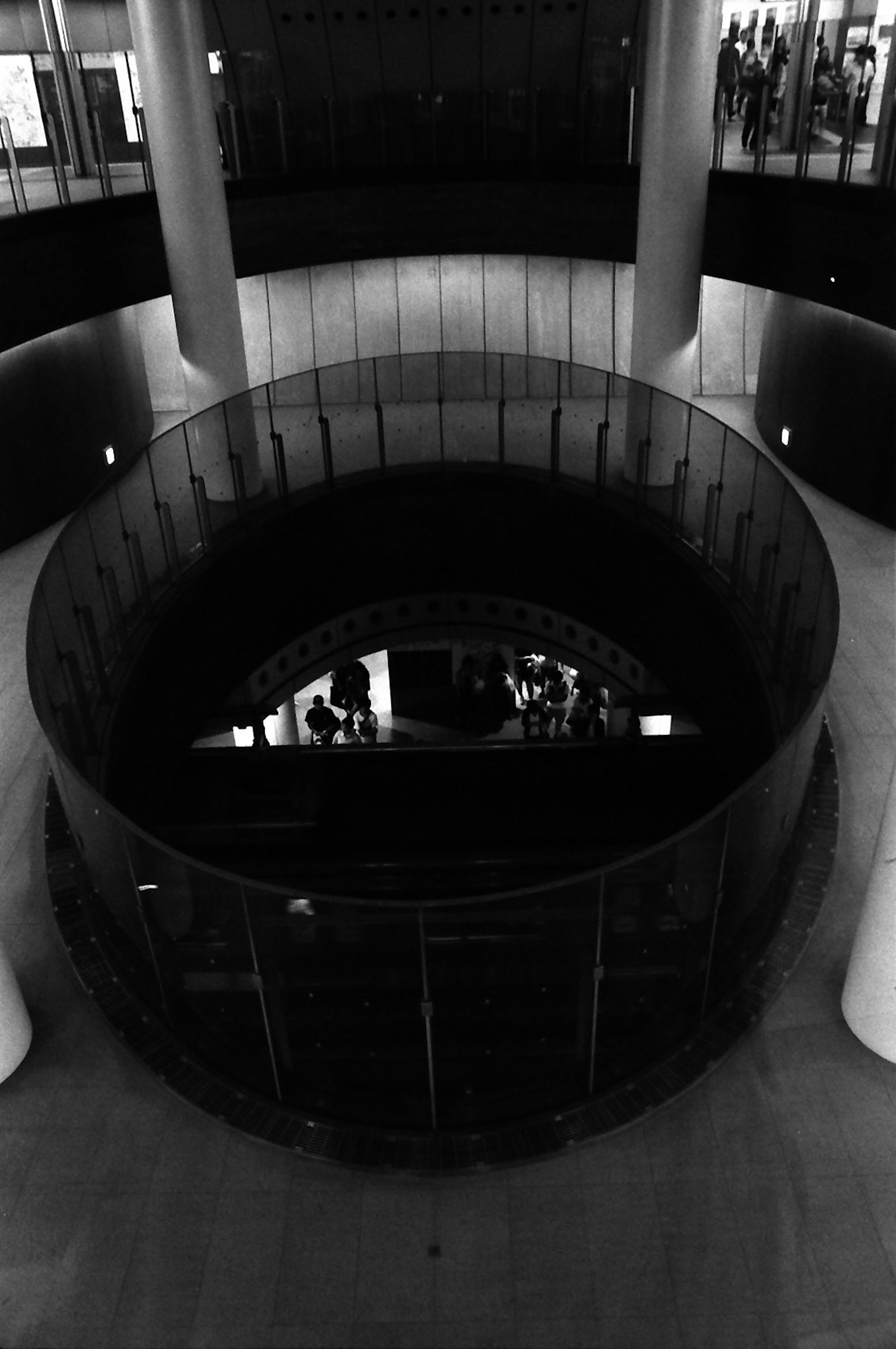 Modern interior circular structure in black and white people silhouettes visible