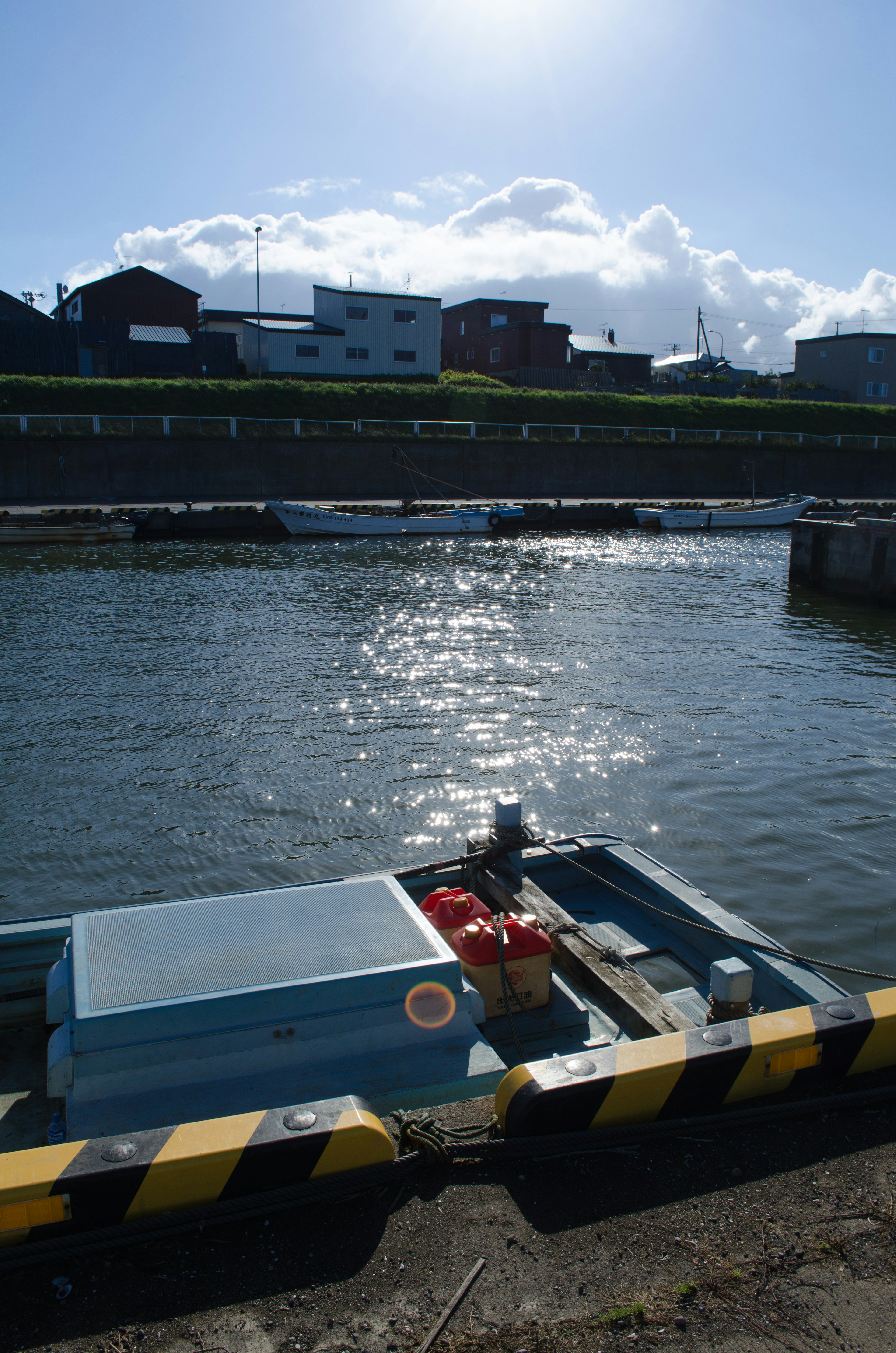 Kleinboot auf dem Wasser mit Sonnenlicht, das sich auf der Oberfläche spiegelt