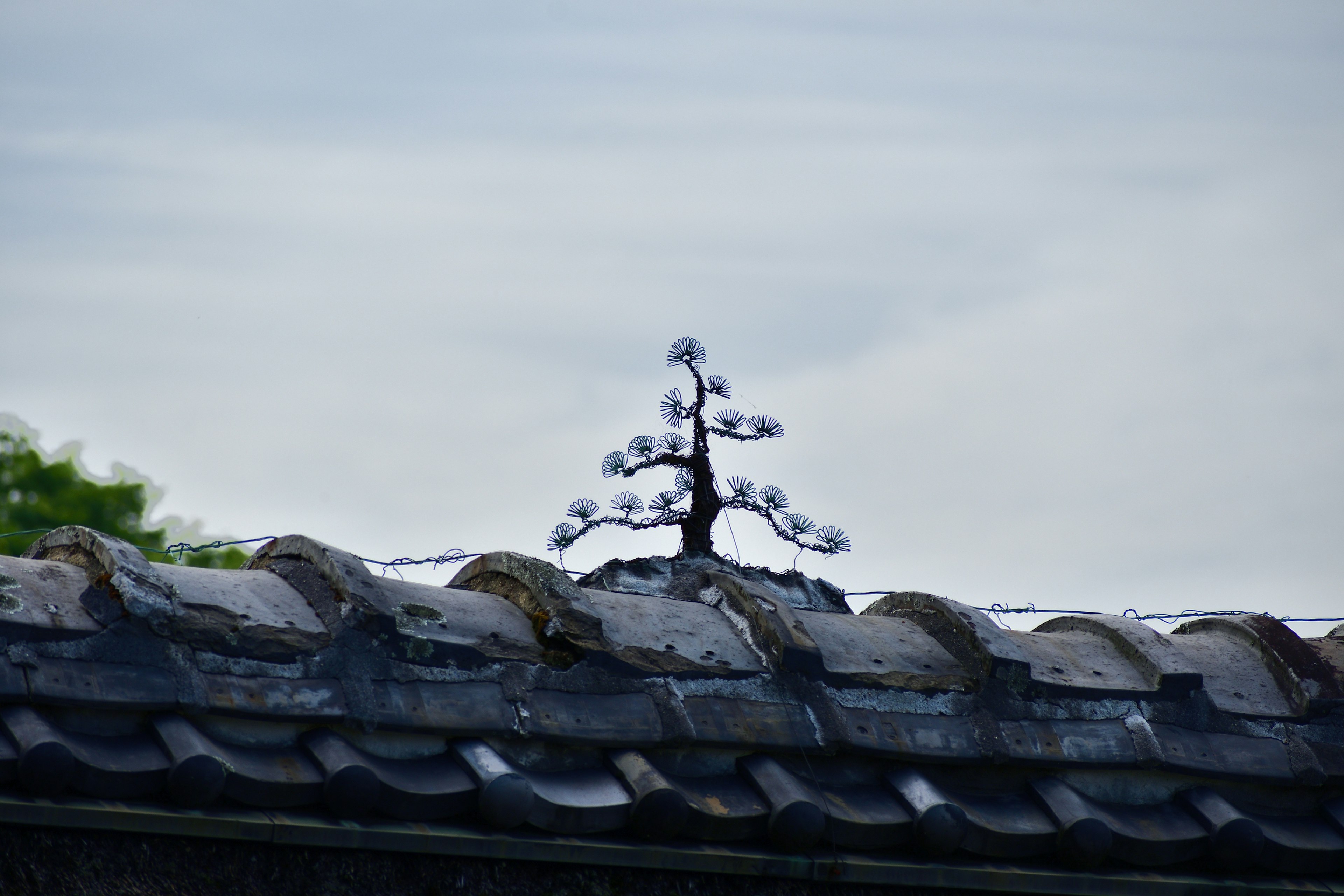 Decorative tree-shaped object on top of a roof