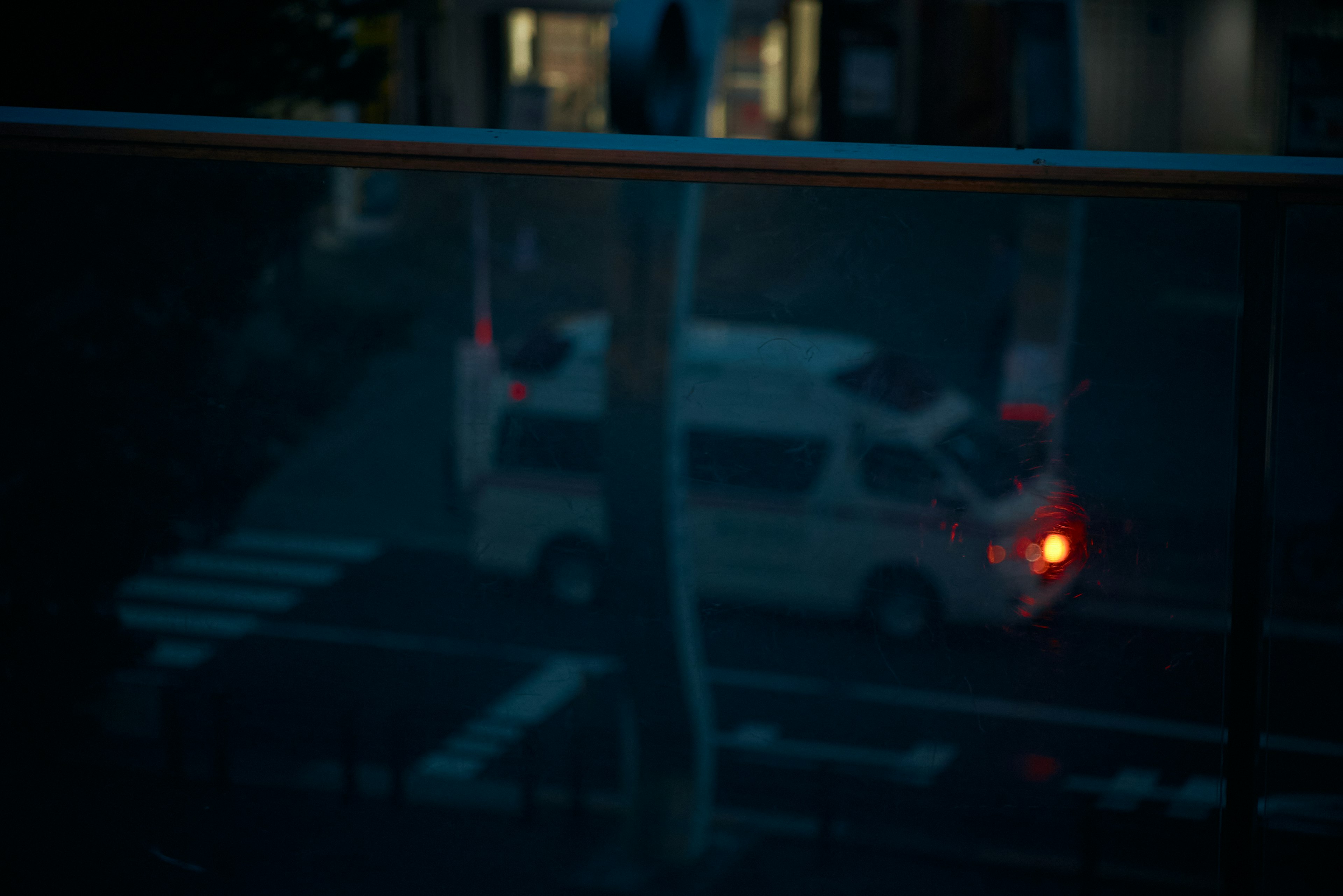 A white vehicle with red tail lights illuminated in a dark setting