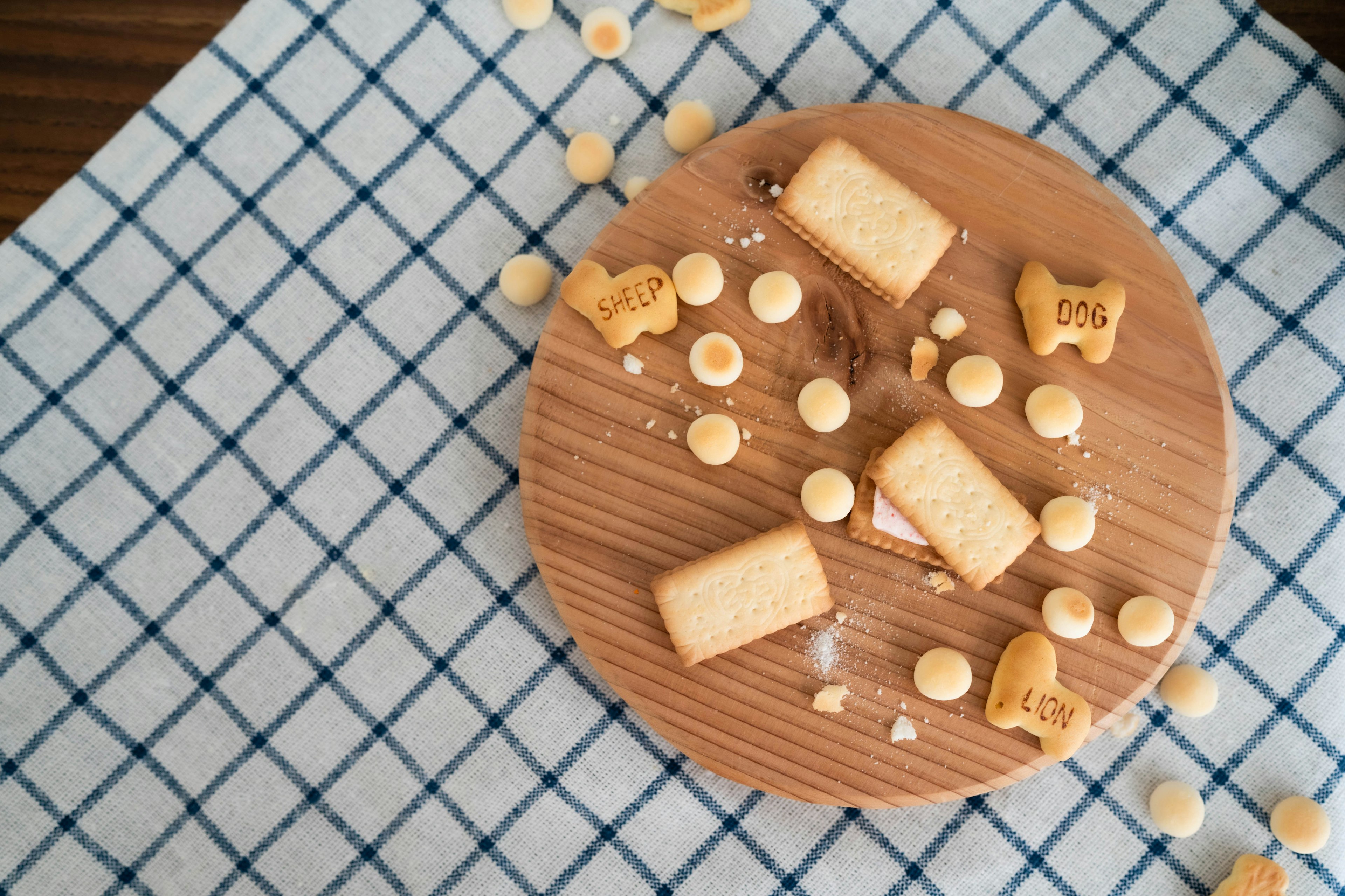 Cookies and candies scattered on a wooden plate