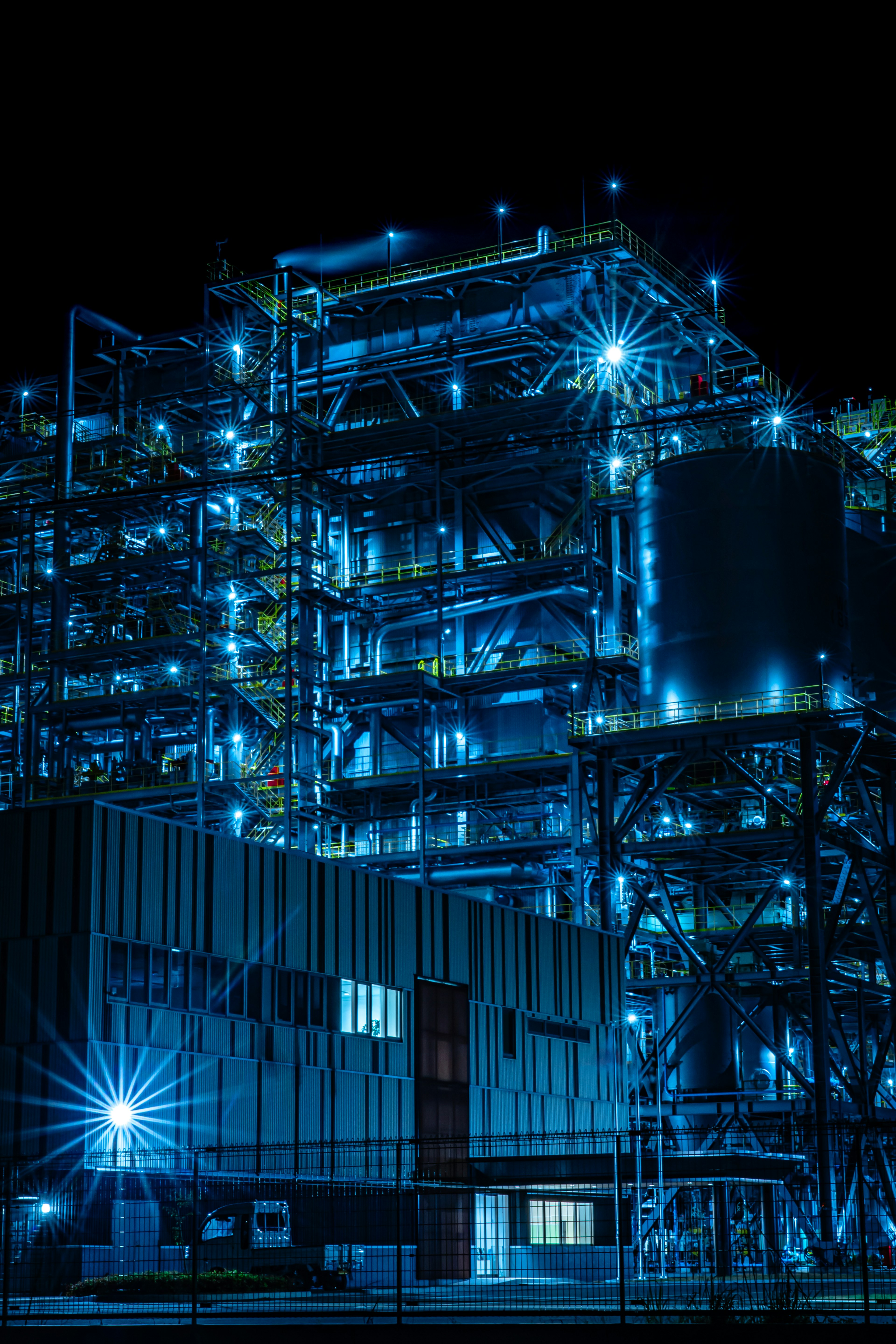 Installation industrielle illuminée par des lumières bleues la nuit