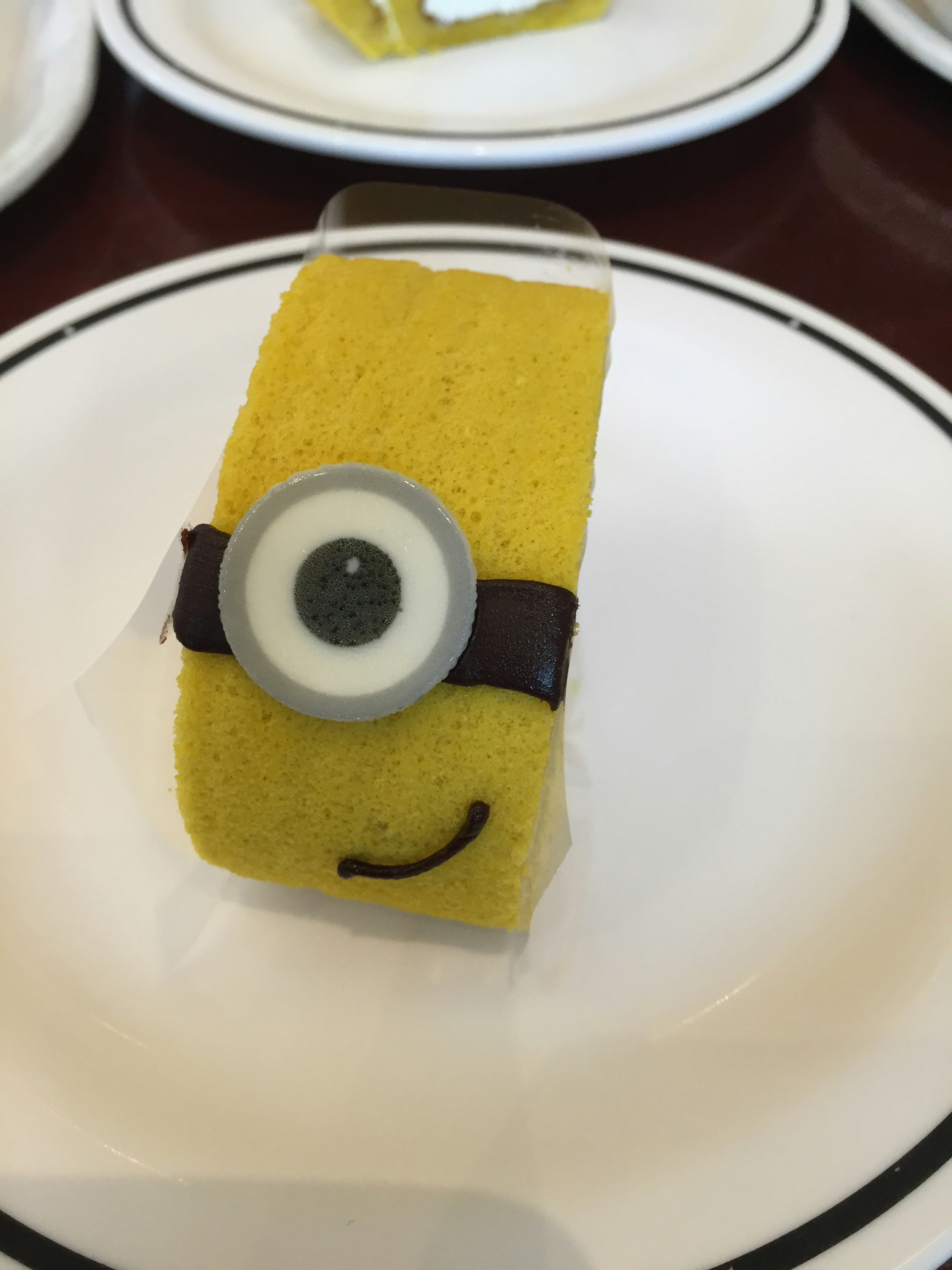 Yellow cake roll designed as a Minion featuring a smile and eye decoration