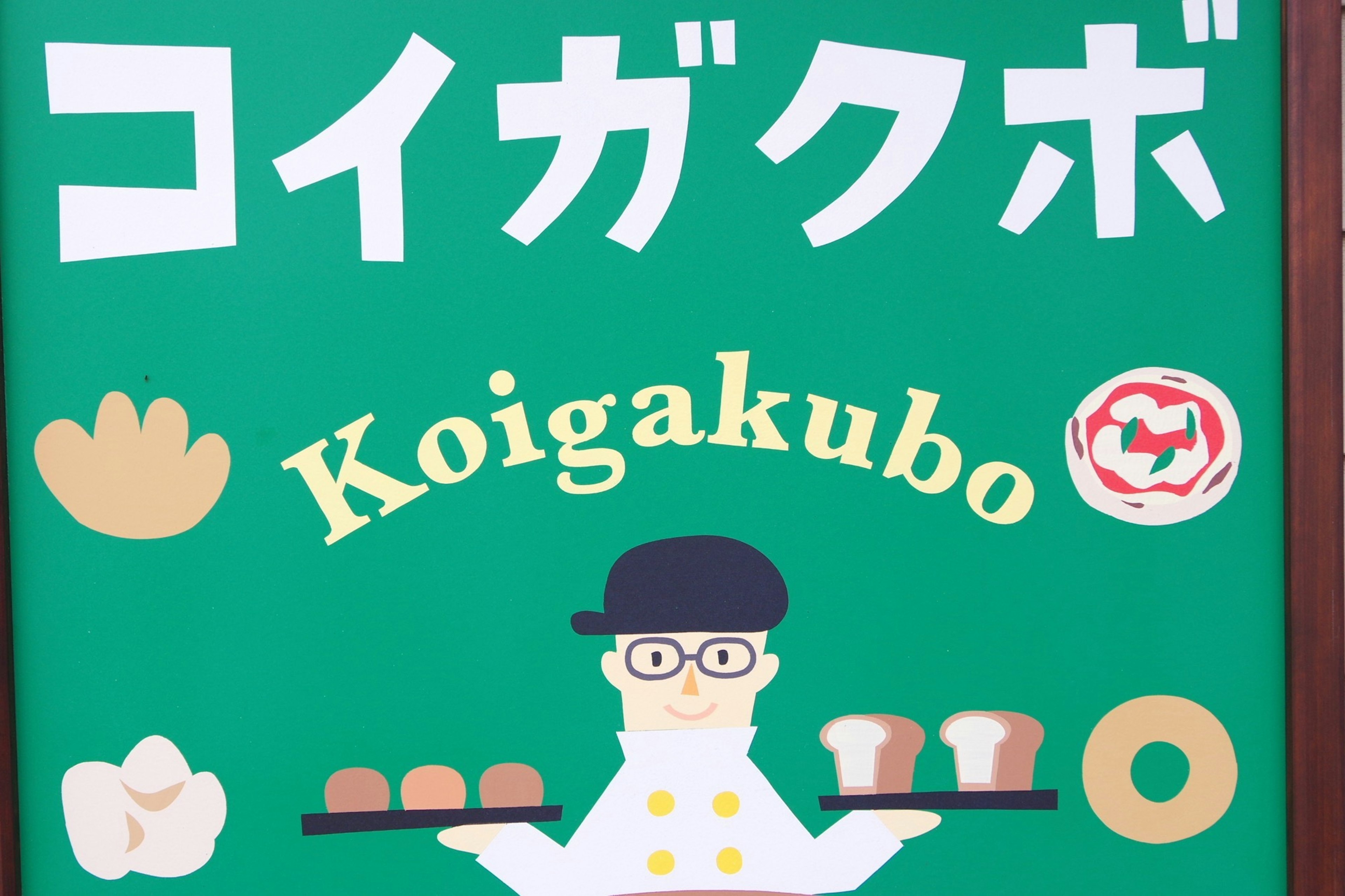 Green sign featuring Koigakubo character holding bread