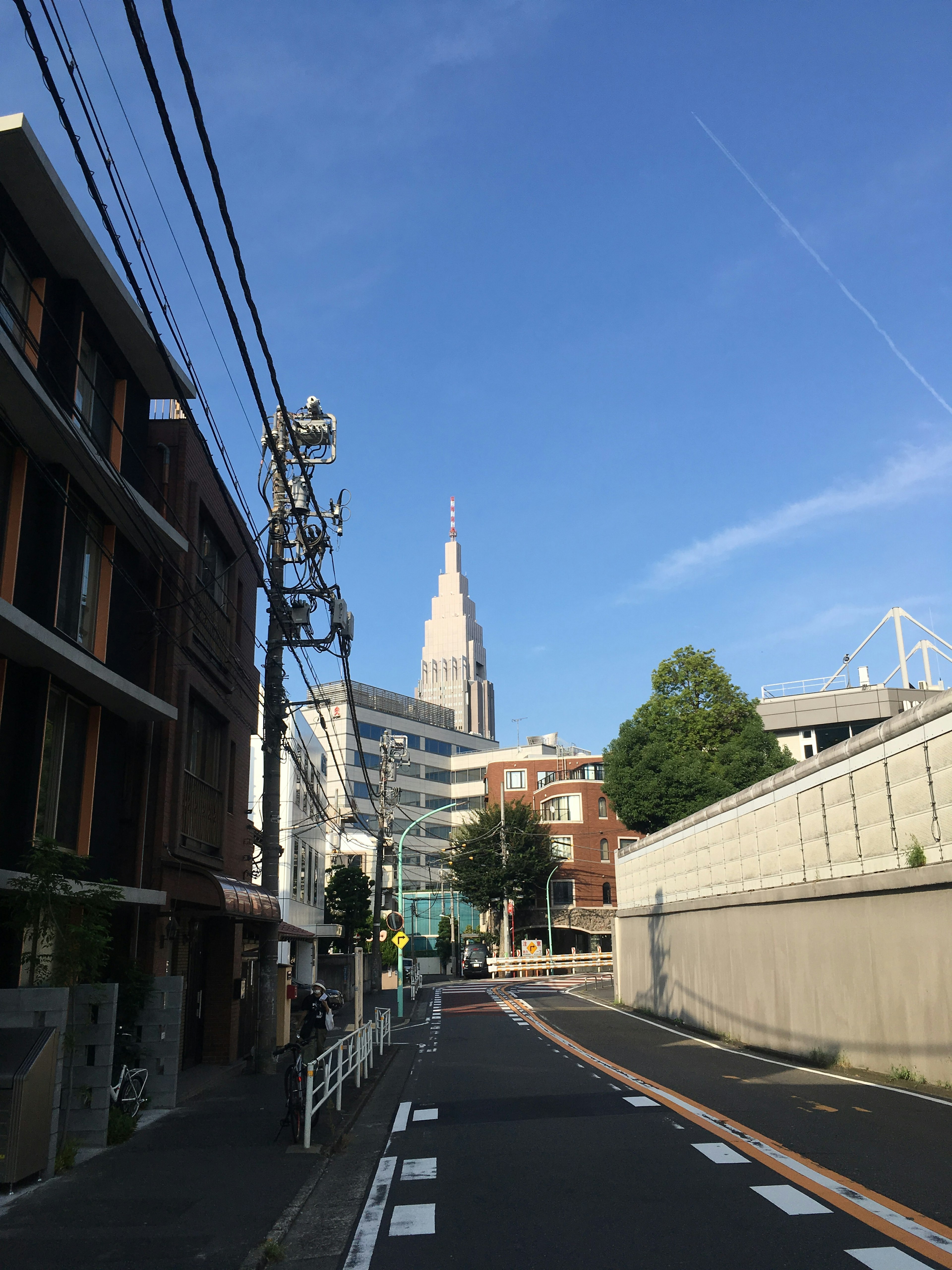 Pemandangan jalan dengan gedung pencakar langit Shinjuku di bawah langit biru