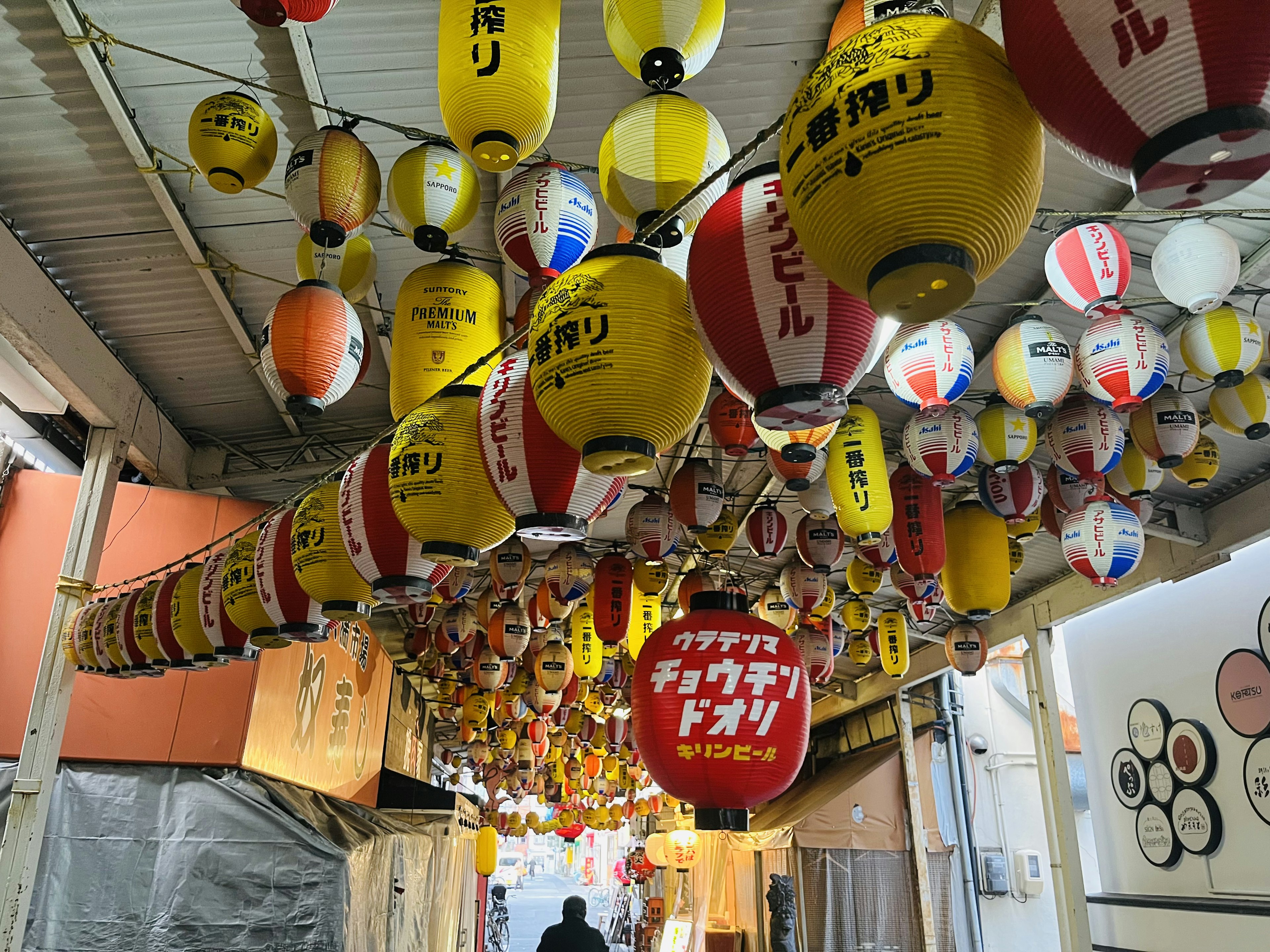 色とりどりの提灯が吊るされた屋台通りの風景