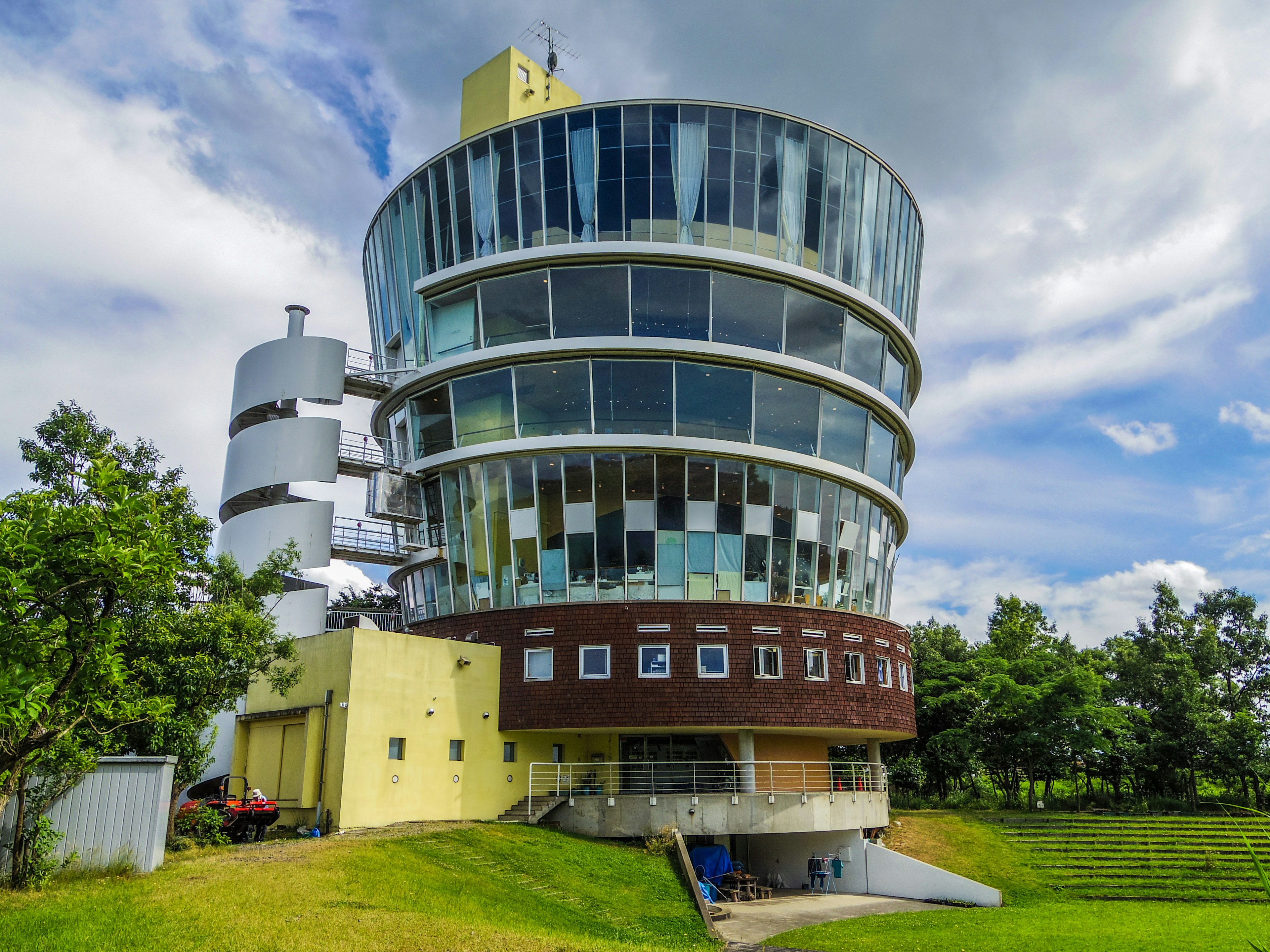 Unique circular building under a blue sky in a lush green setting