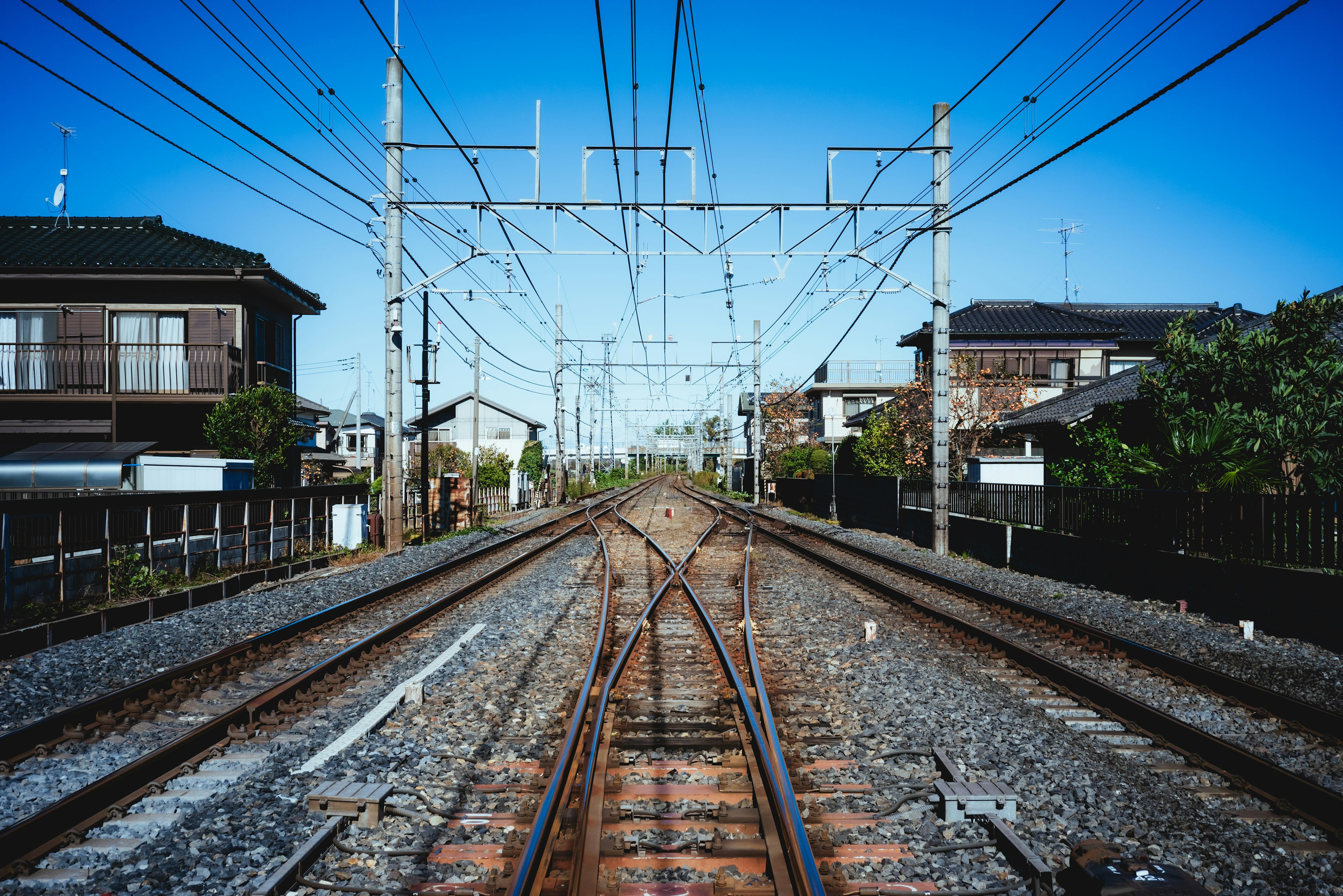 青空の下に広がる鉄道の風景と周囲の住宅