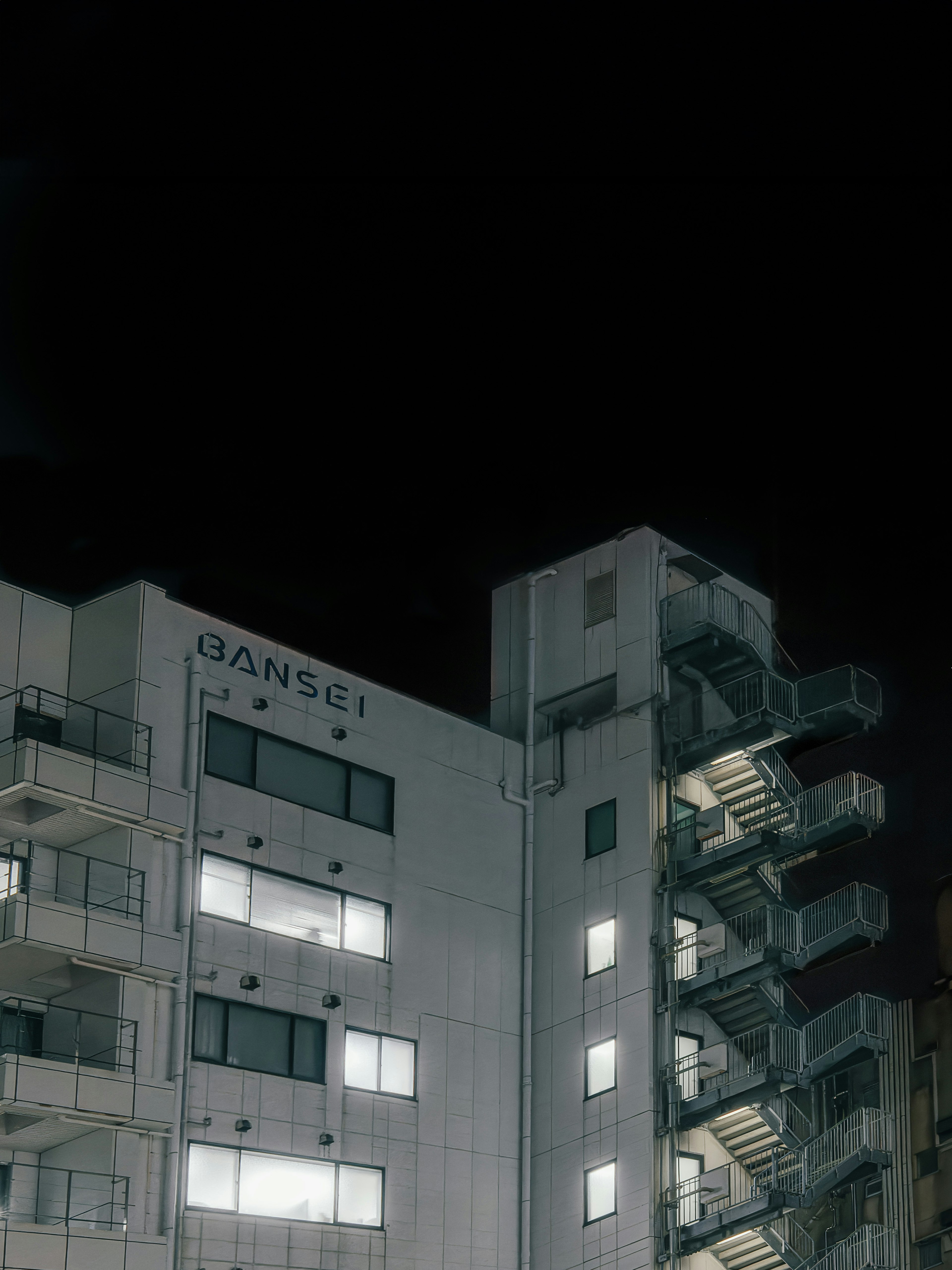 Fachada de un edificio de apartamentos blancos por la noche